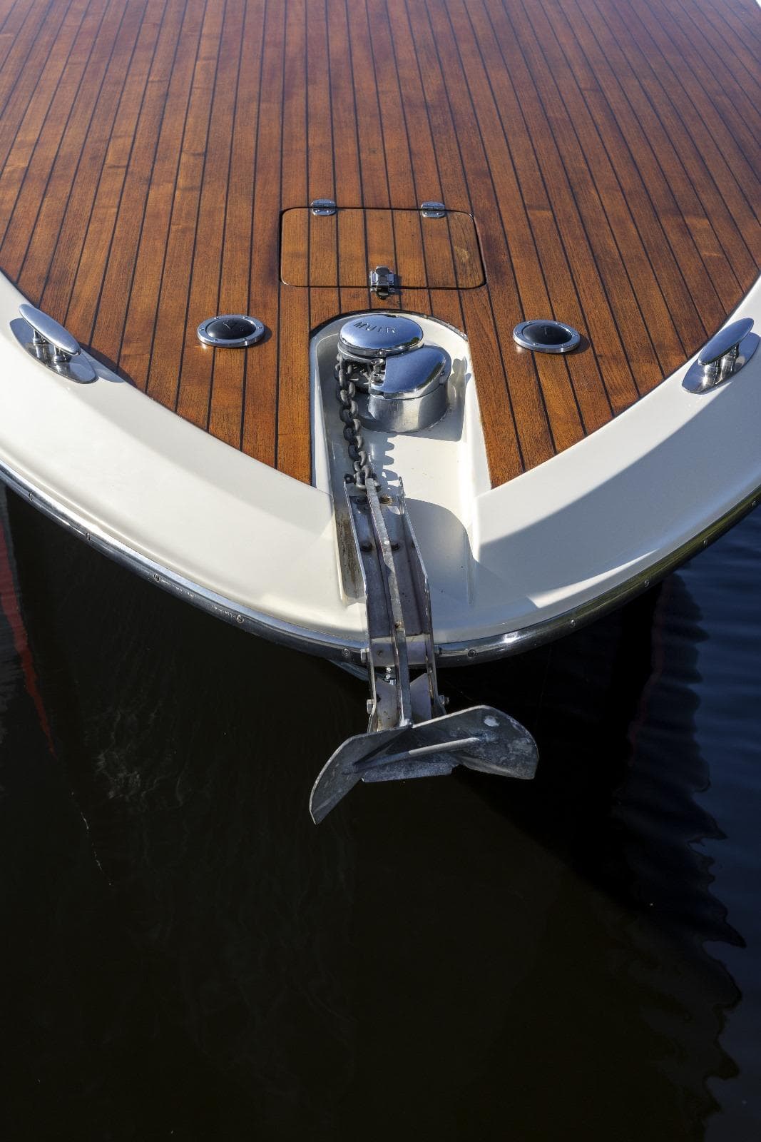 1997 Kavalk 30 boat with wooden deck and anchor in water.