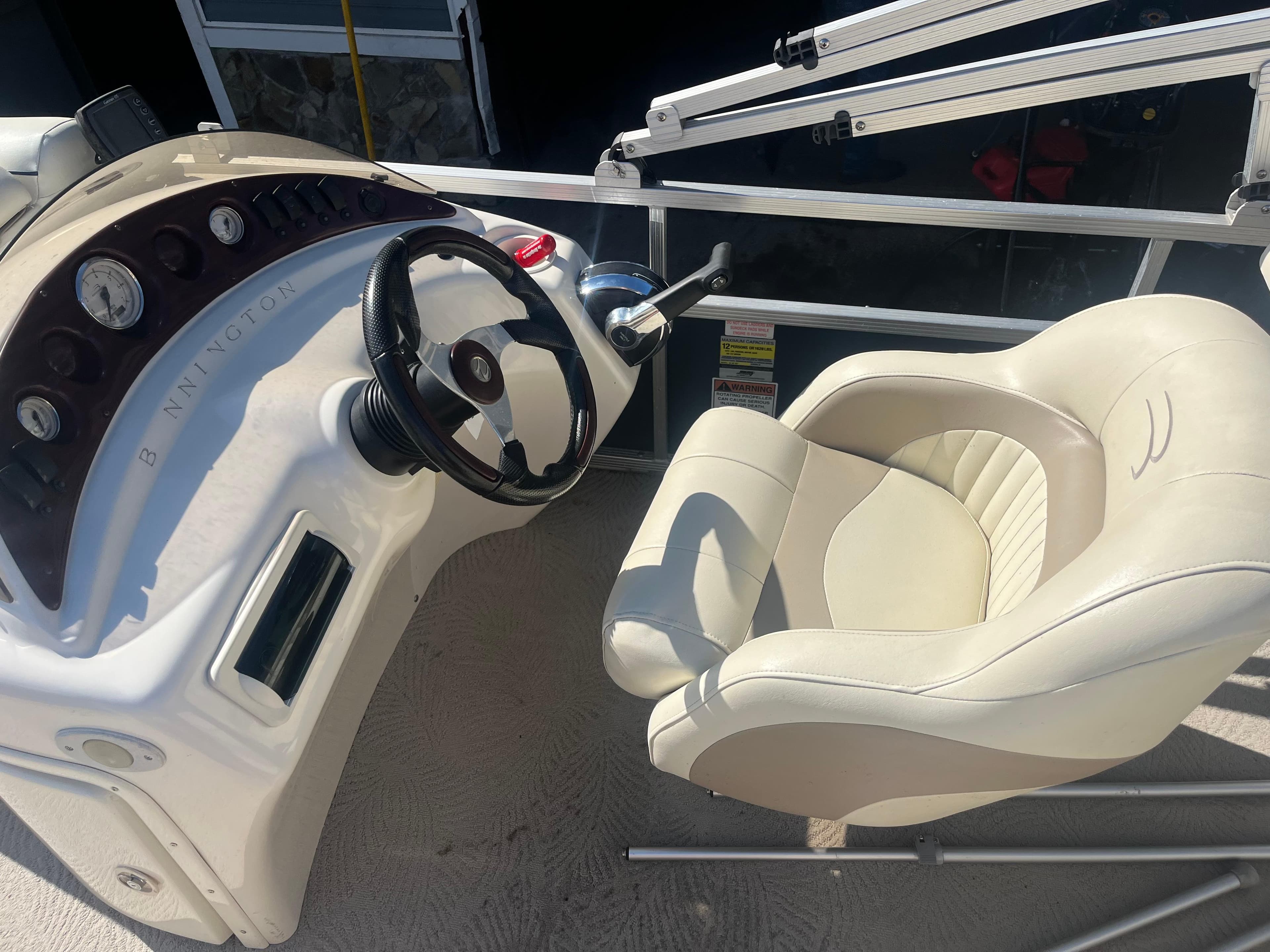 2009 Bennington 2275 GS boat helm with steering wheel and captain's chair.
