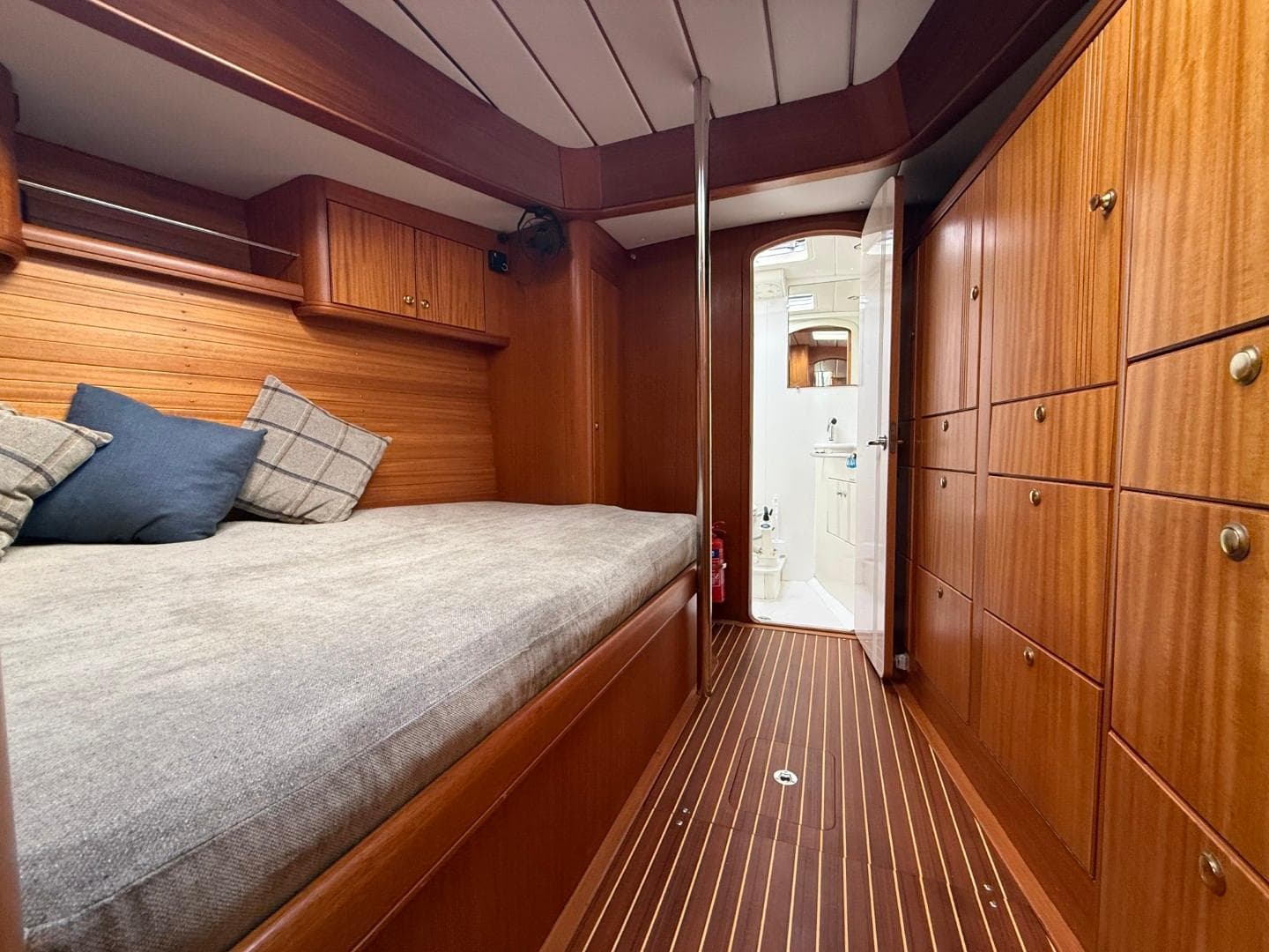 Luxurious 2002 Najad 490 yacht cabin with wooden interior and cozy bedding.