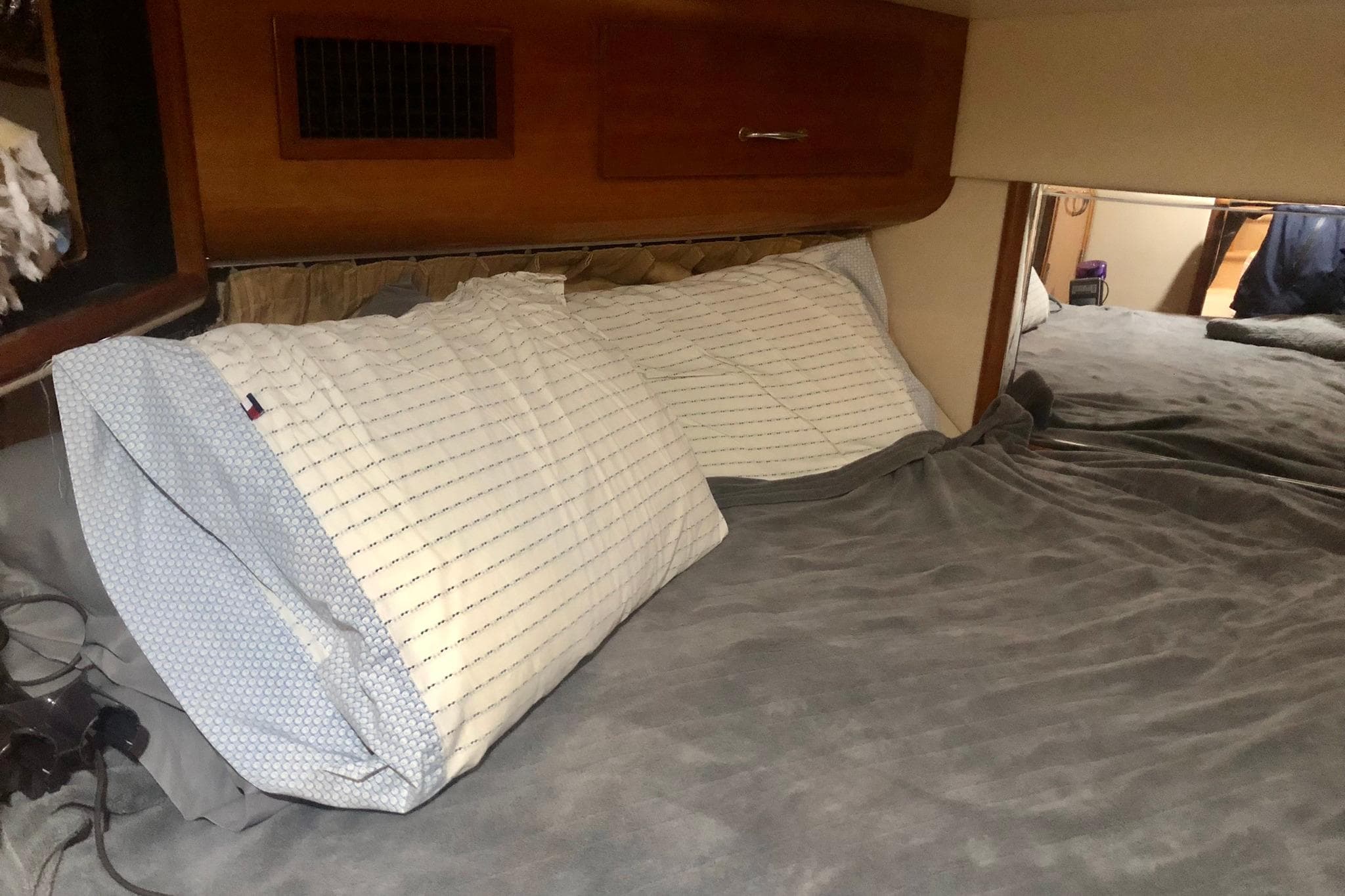 Cozy bedroom interior of 2005 Carver 444 Cockpit Motor Yacht with pillows and bedding.