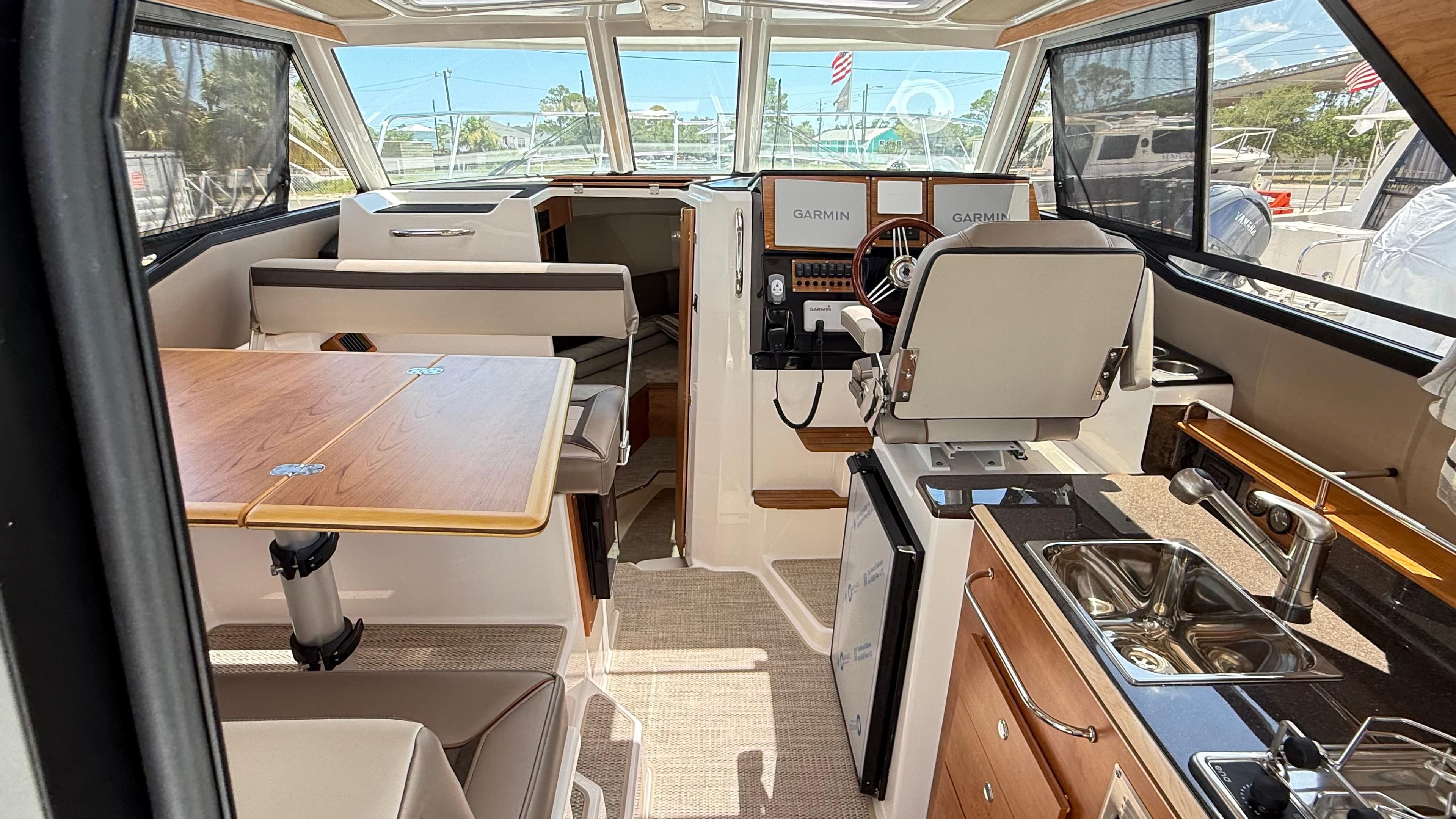 Interior of 2026 Cutwater C-288 Coupe, featuring helm, seating, and kitchenette.
