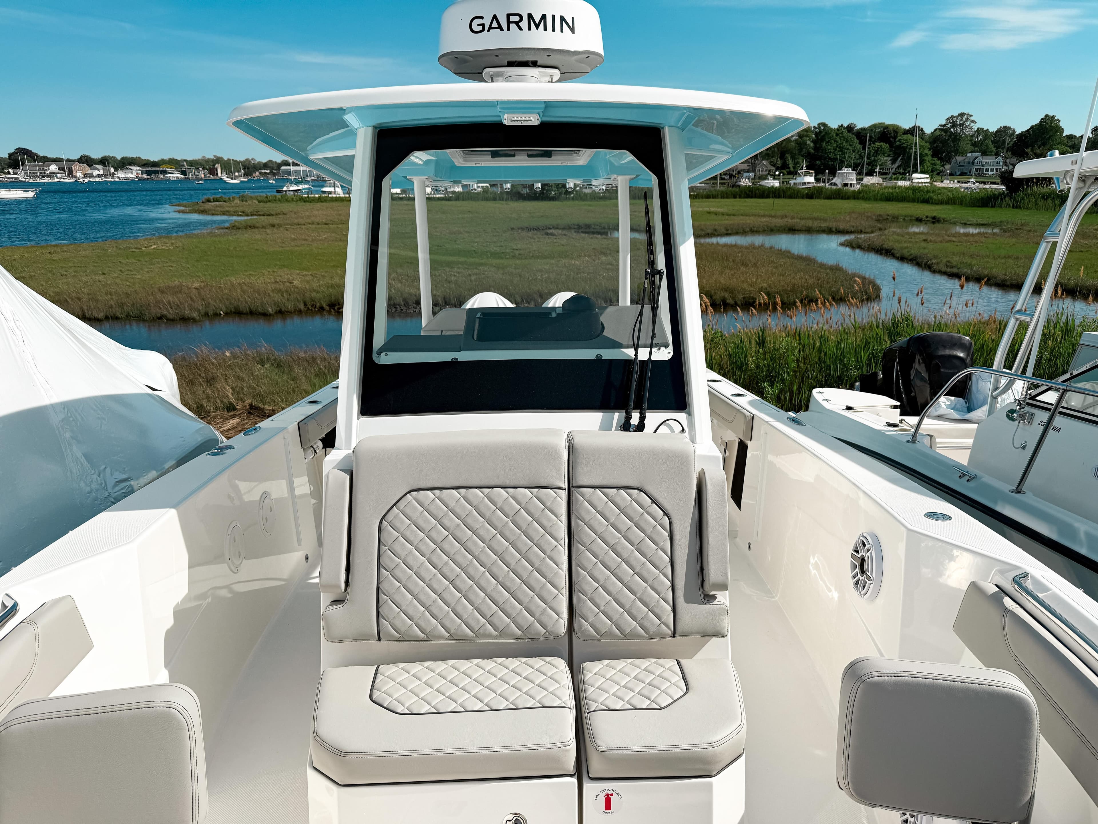 2025 Pursuit S 288 Sport boat with Garmin equipment, docked near a scenic shoreline.
