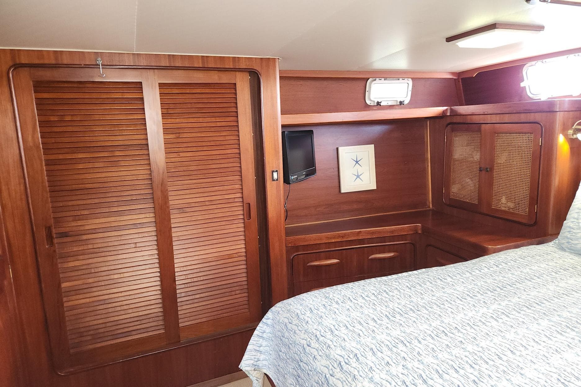 Cozy cabin interior of 1980 Gulfstar 44 Motor Cruiser with wood paneling and bed.