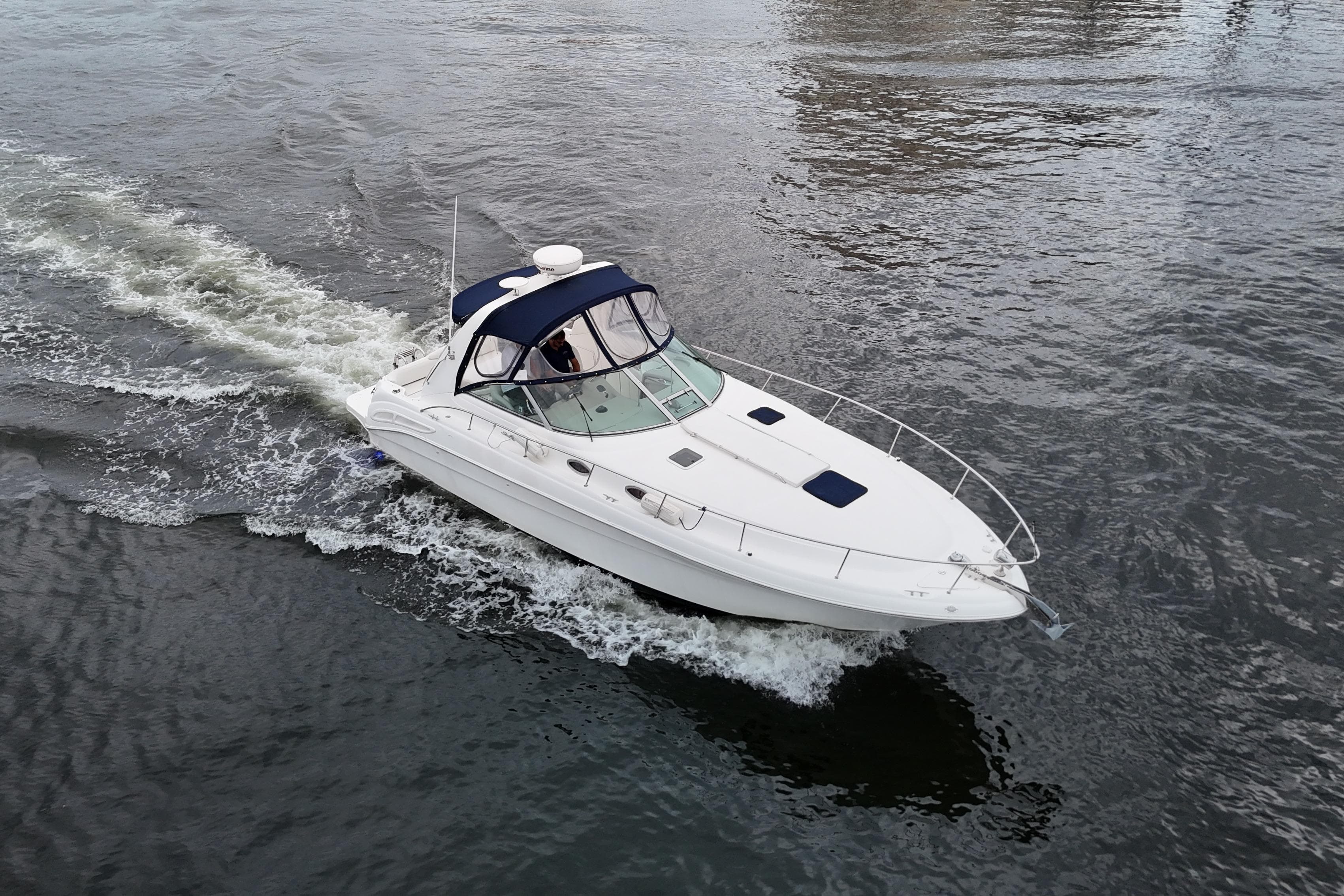 1999 Sea Ray 340 boat cruising on open water, aerial view.