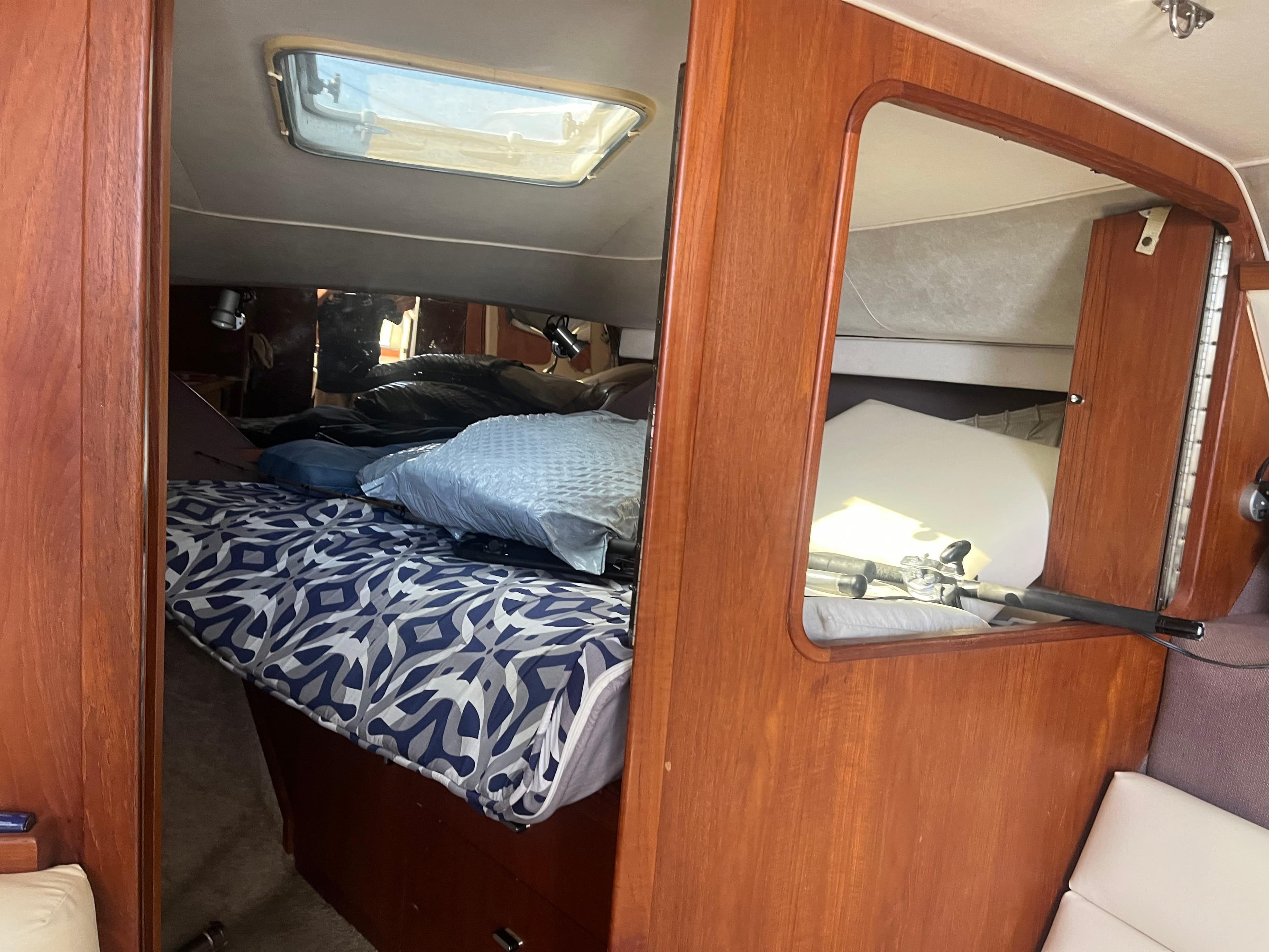 Interior cabin of 1989 Tiara Yachts 33OPEN with bed and wooden paneling.