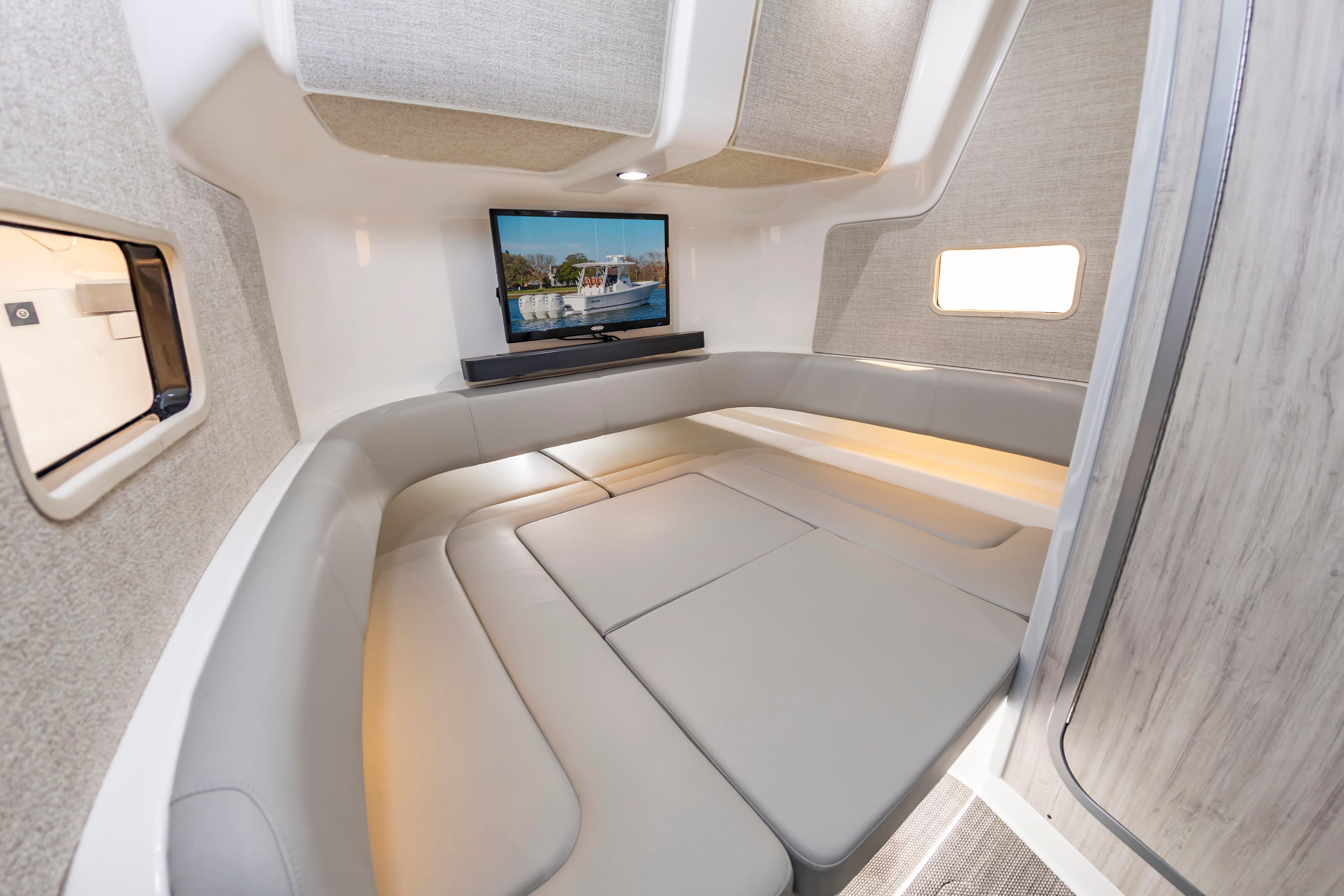 Luxurious interior of 2026 Regulator 37 boat with cozy seating and mounted TV.
