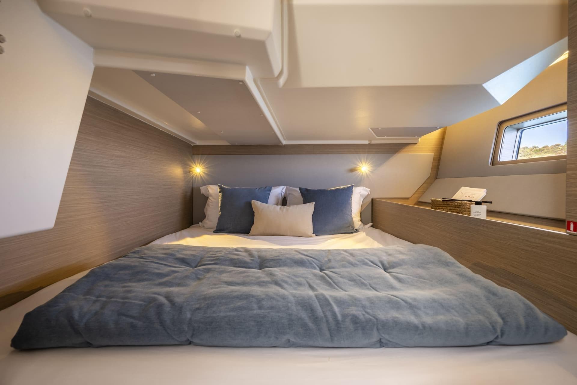 Luxurious cabin interior of 2026 Beneteau Oceanis 52 yacht with cozy bedding.