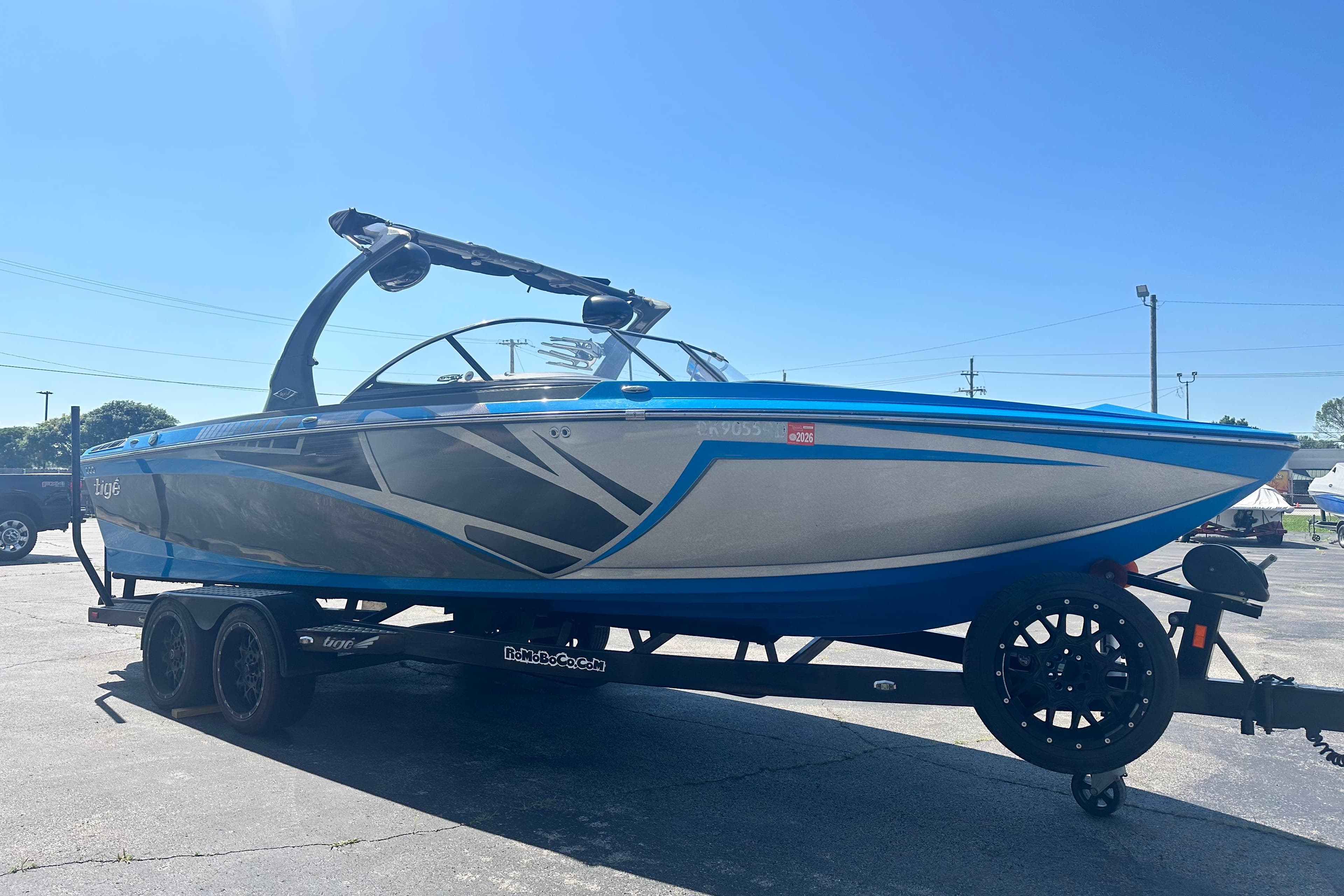 2016 Tige Z3 boat on trailer, blue and gray design, parked outdoors.