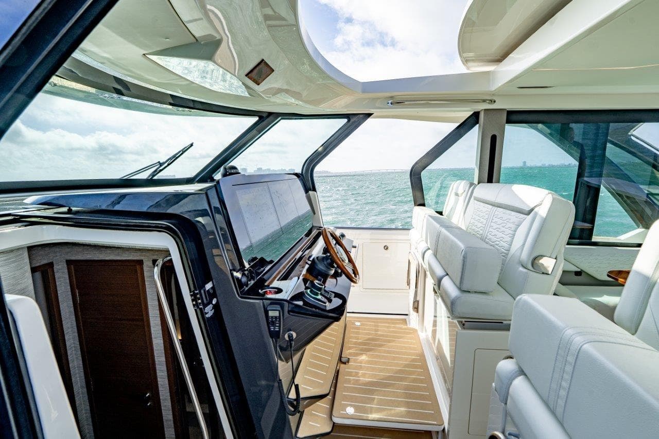 Luxurious interior of 2026 Tiara Yachts 56 LS, featuring modern helm and plush seating.