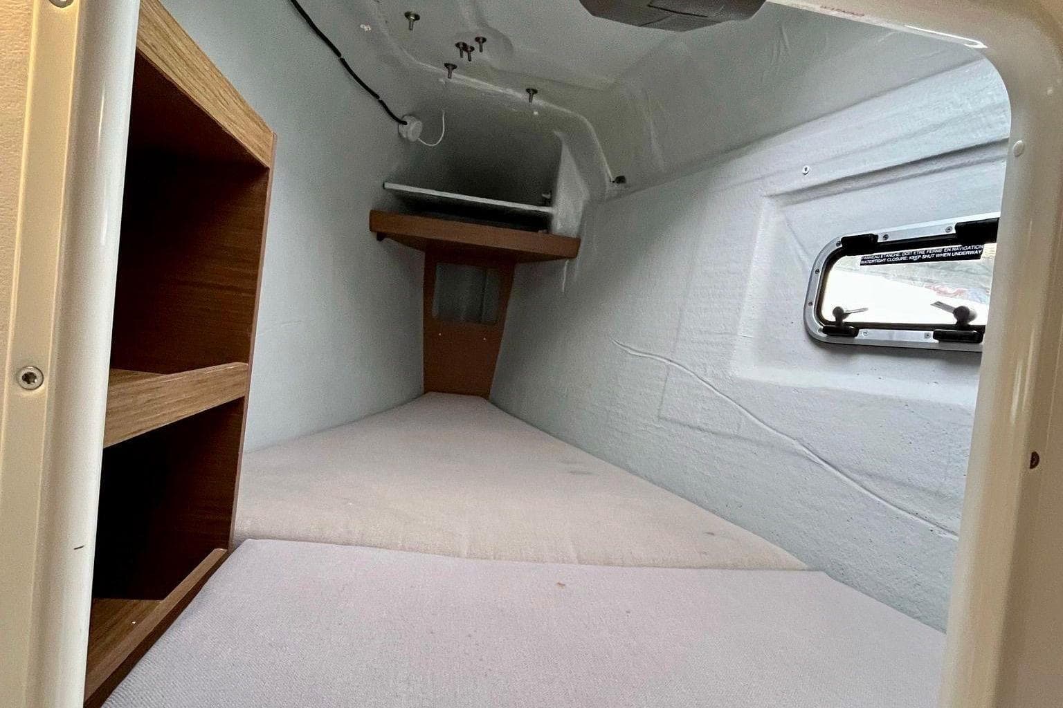 Interior cabin of 2018 Lagoon 42 catamaran with shelving and window.