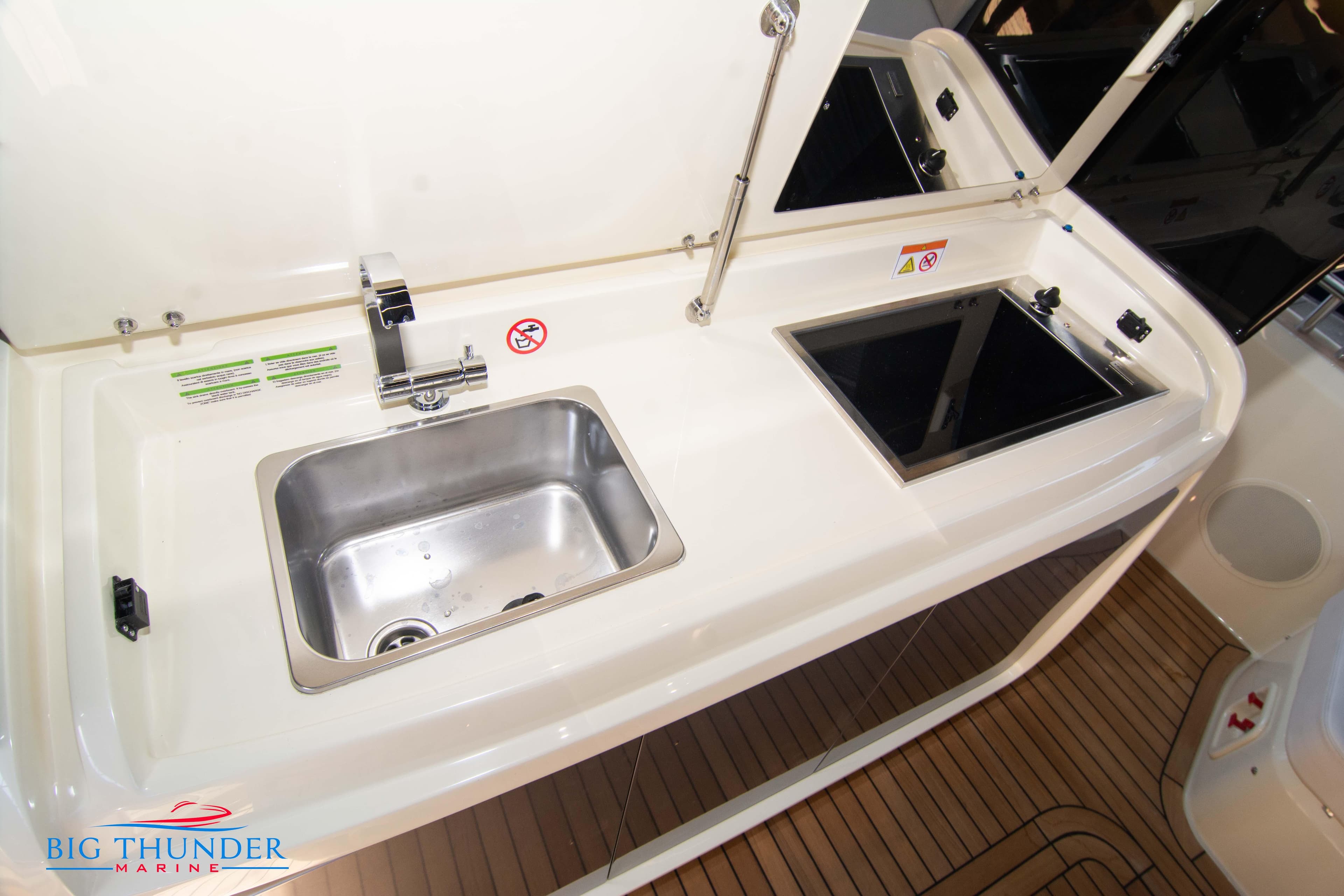 2024 Invictus GT370S boat kitchen with sink and stove, Big Thunder Marine.
