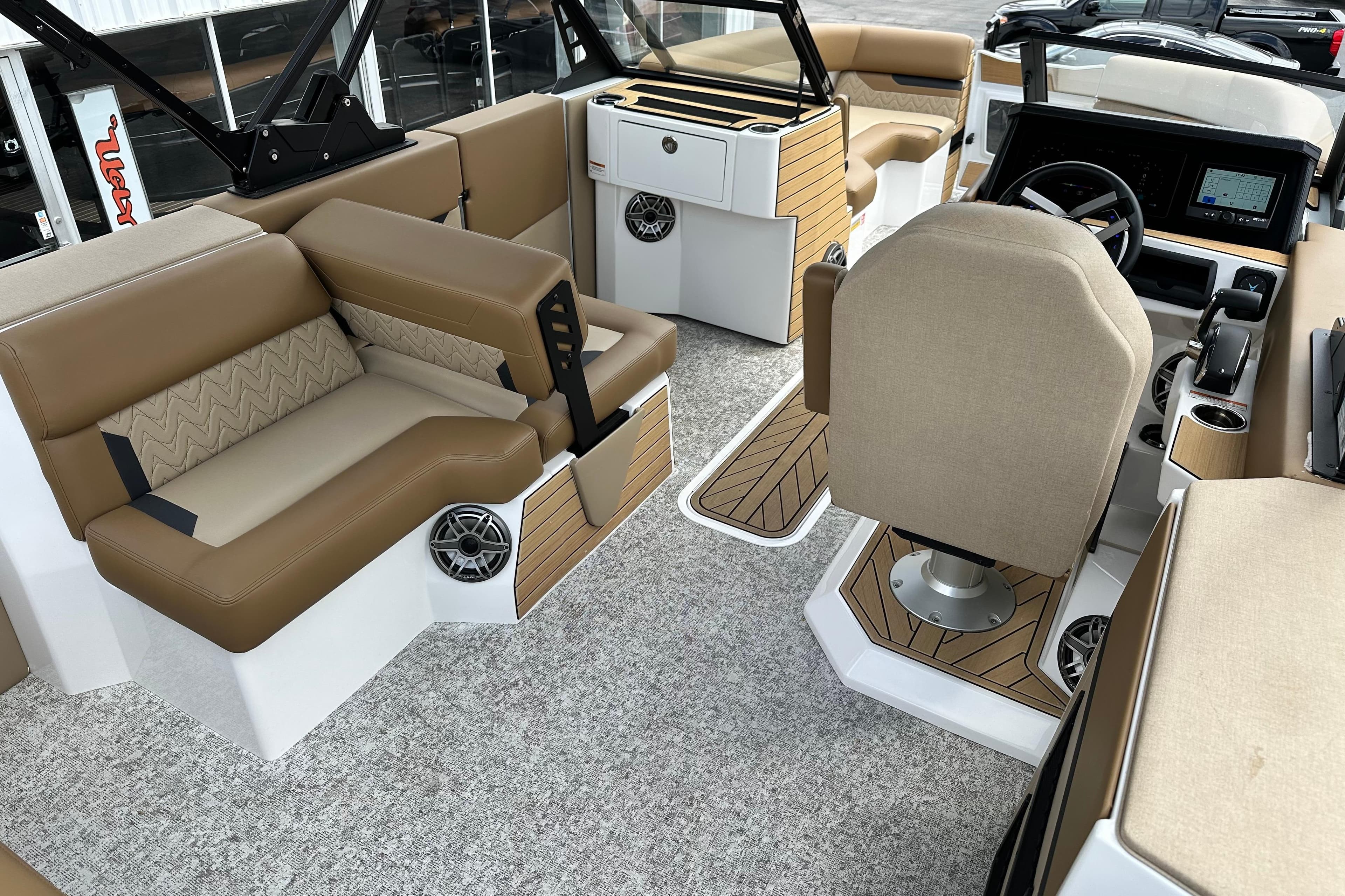 Luxurious interior of 2026 Revel RS25 boat with beige seating and modern dashboard.