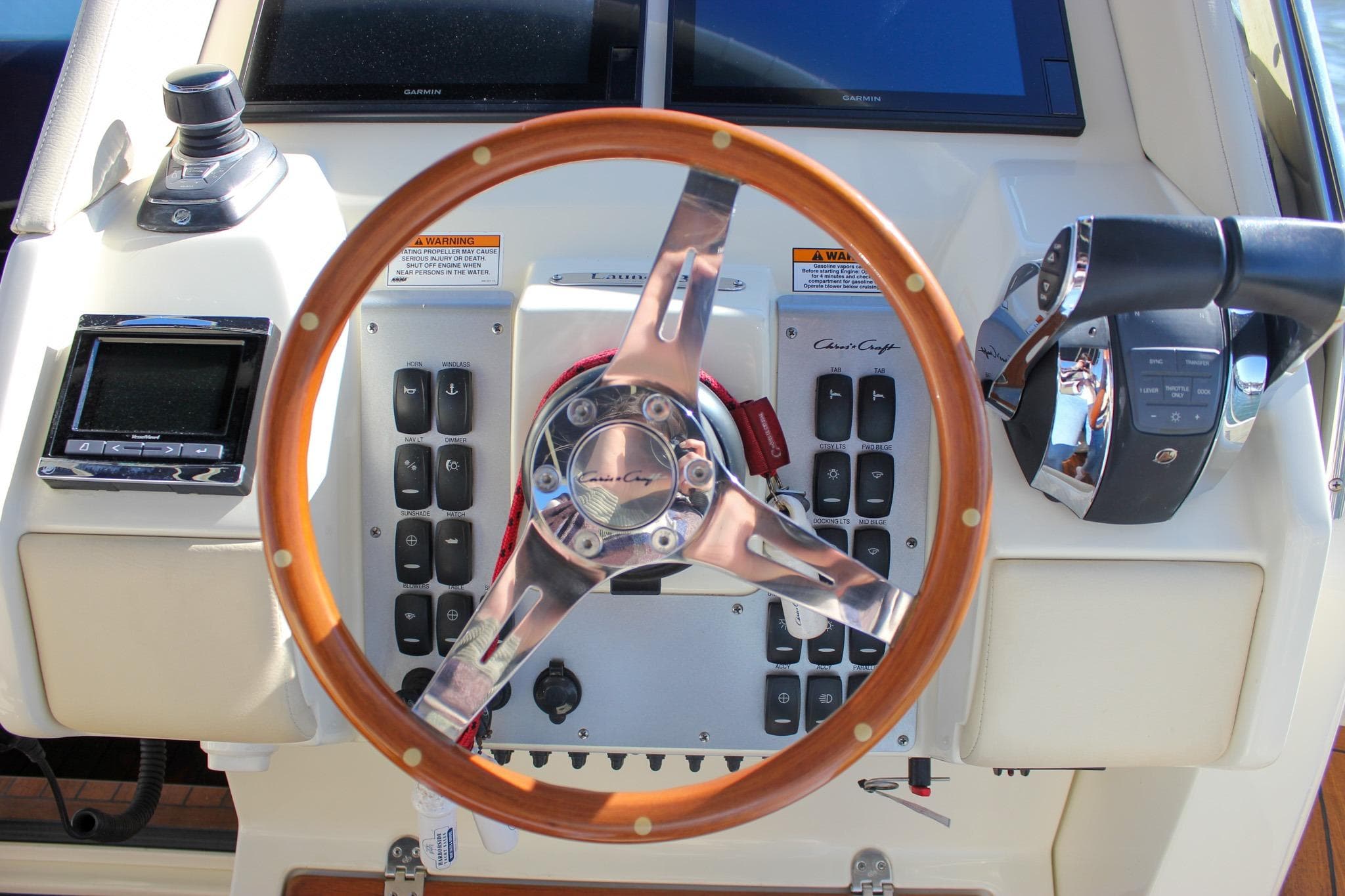 Steering wheel and controls of 2017 Chris-Craft Launch 38 boat cockpit.