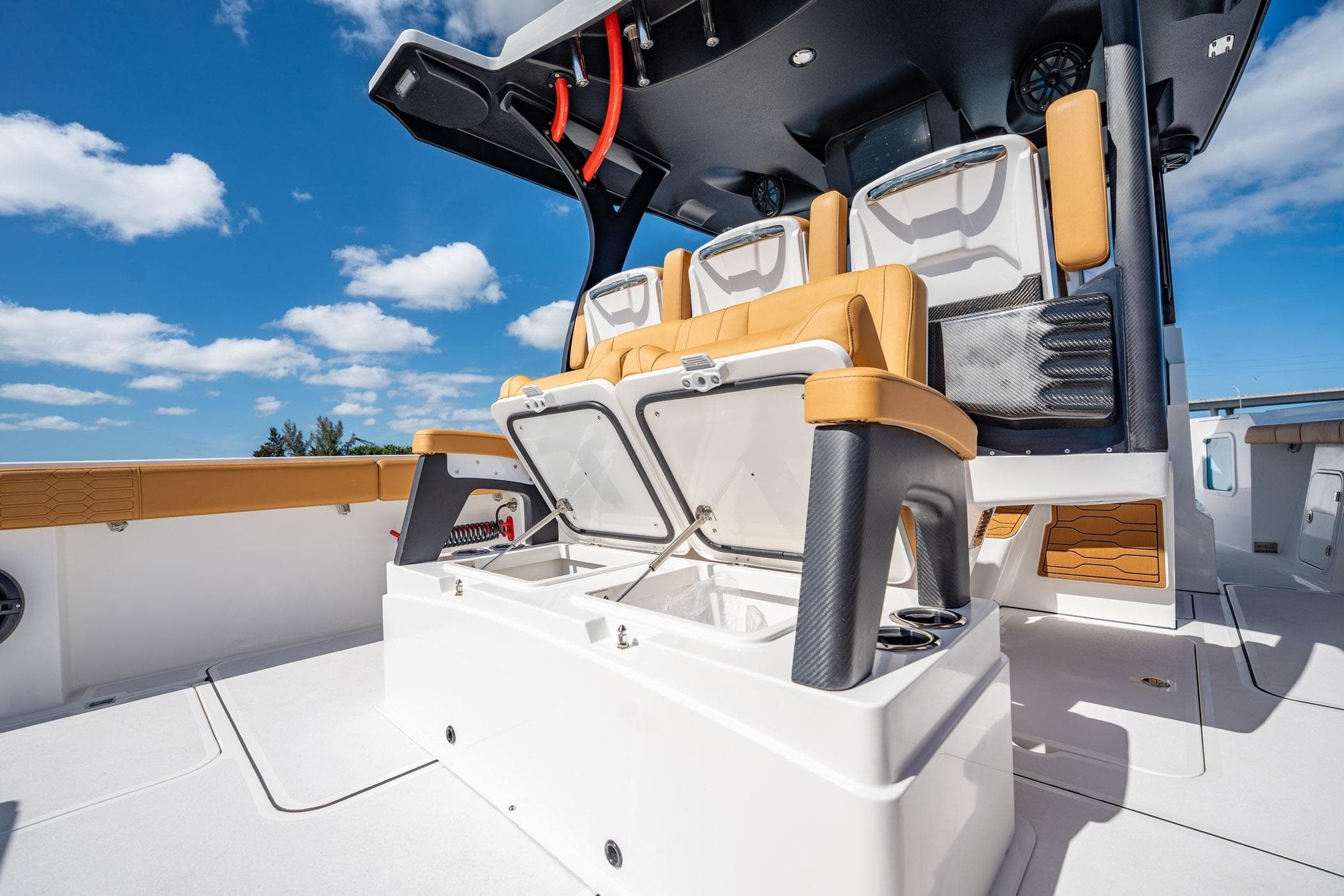 2026 MVI Invicta 30OC boat interior with open storage, luxury seating, and blue sky background.