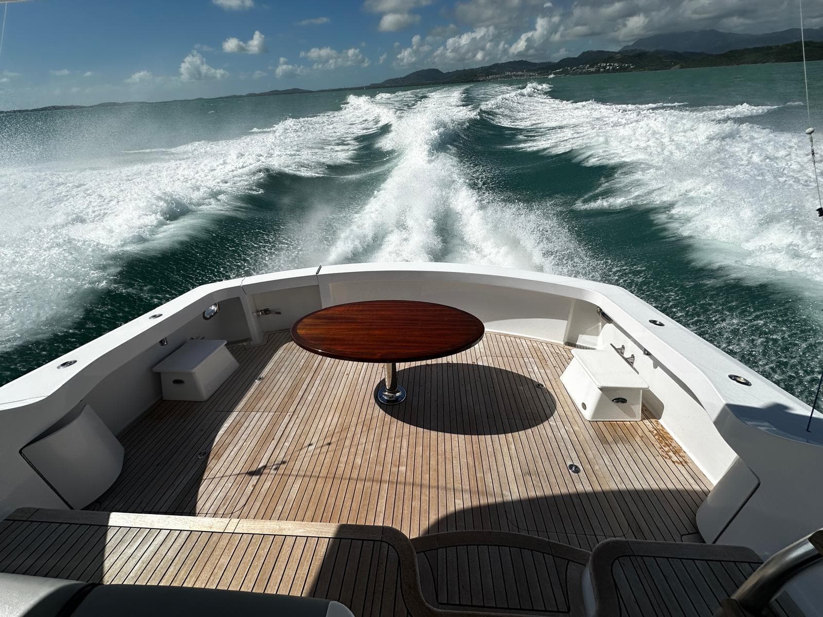 Hatteras GT60 yacht cruising, 2011 model, with wooden deck and ocean view.