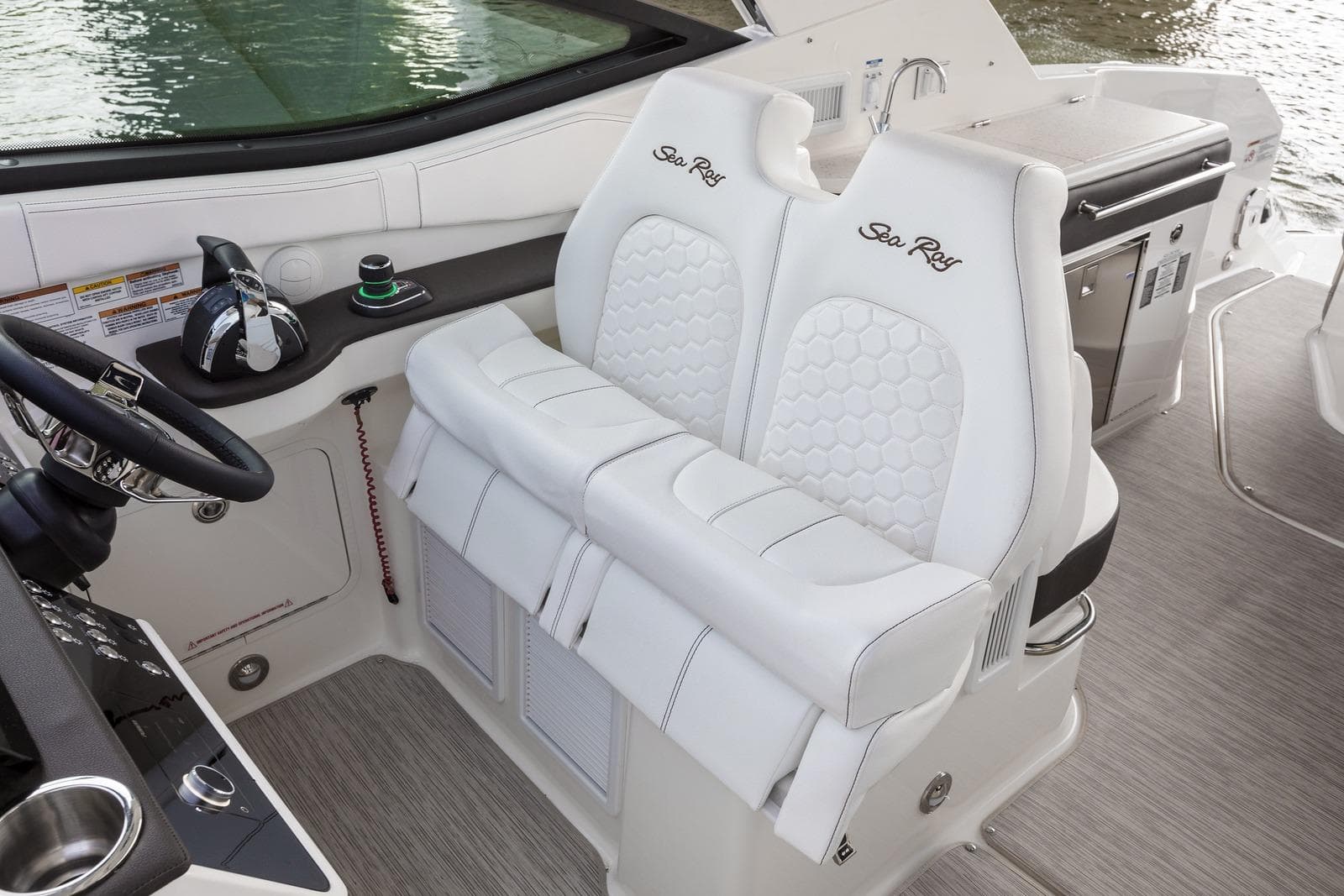 2025 Sea Ray Sundancer 320 cockpit with white leather seats and modern controls.