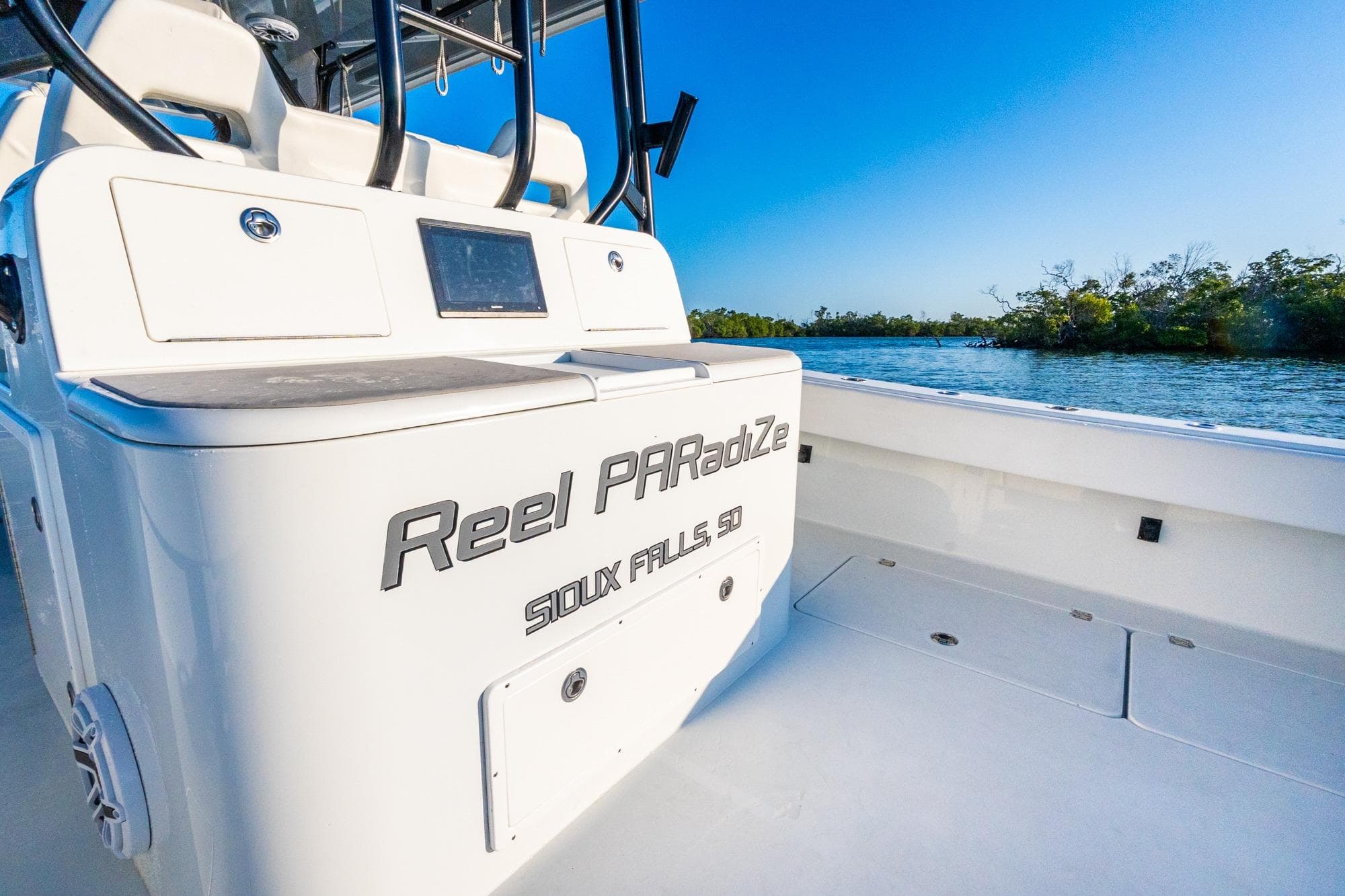 2022 Freeman 42LR boat on water, featuring "Reel PARadiZe" text, clear blue sky.