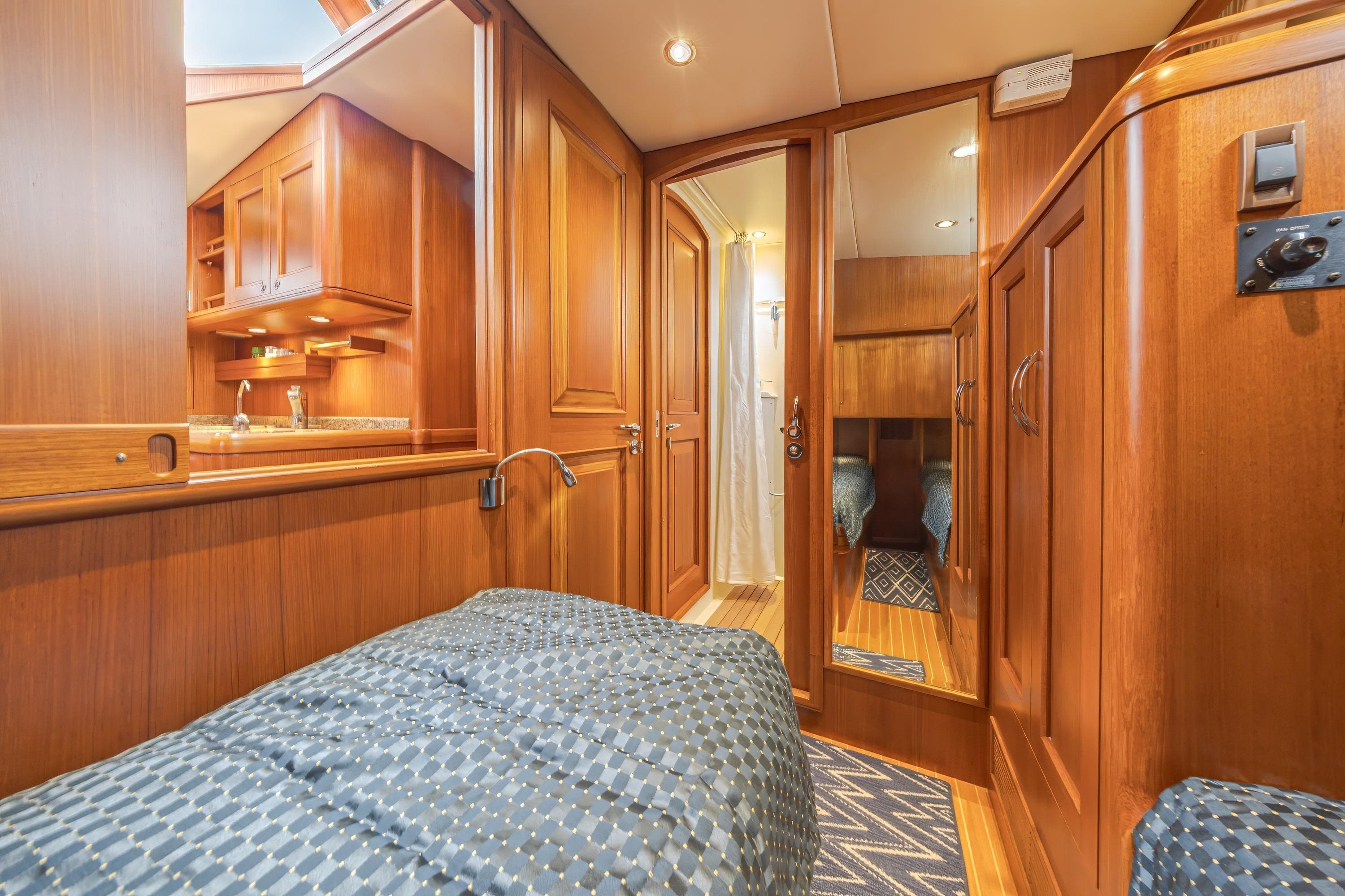 Luxurious 2014 Grand Banks 46 Eastbay SX yacht interior with wood finish and cozy bedding.