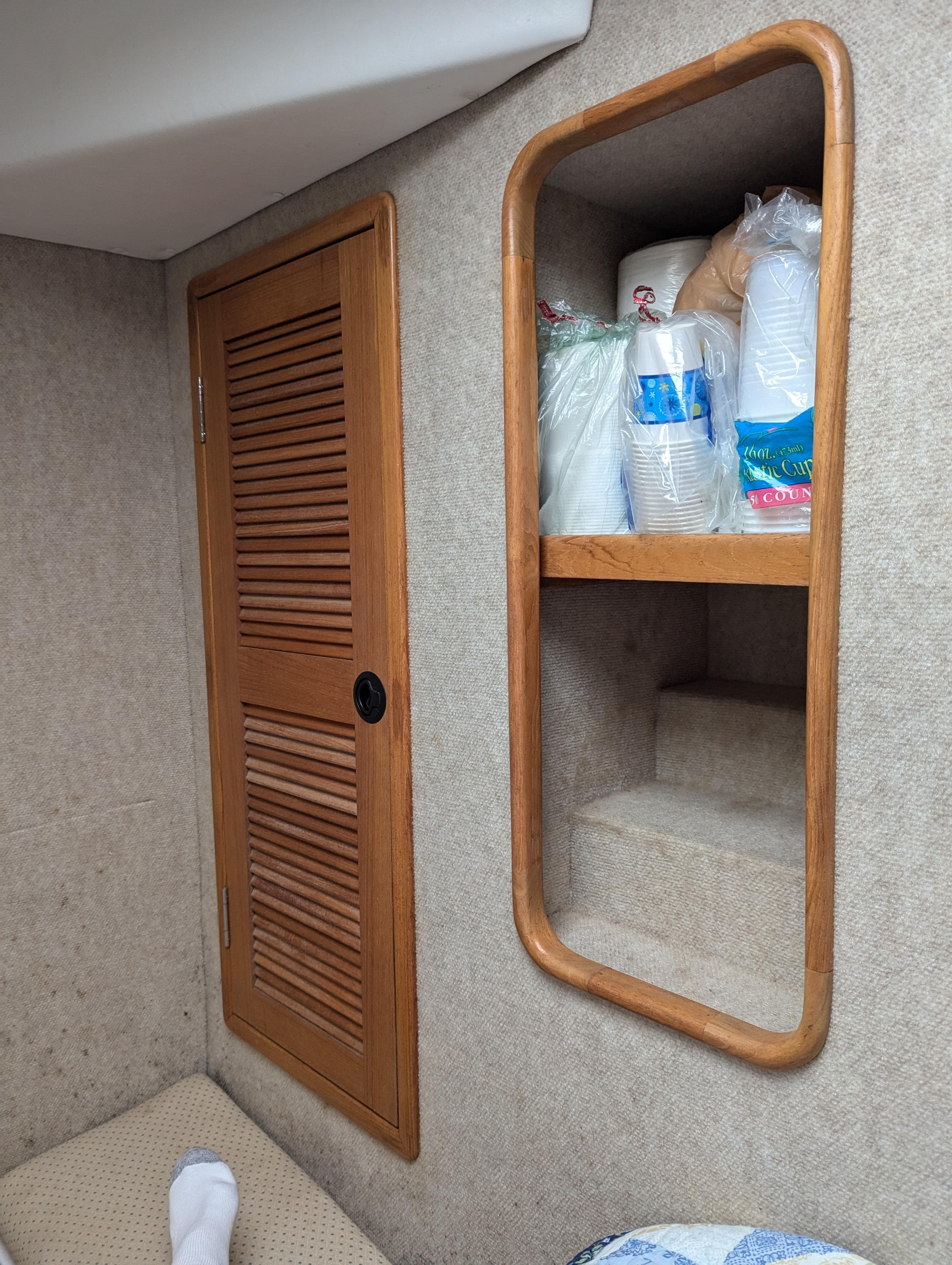 Interior of a 2000 Manta 42 boat with wooden cabinet and shelves.