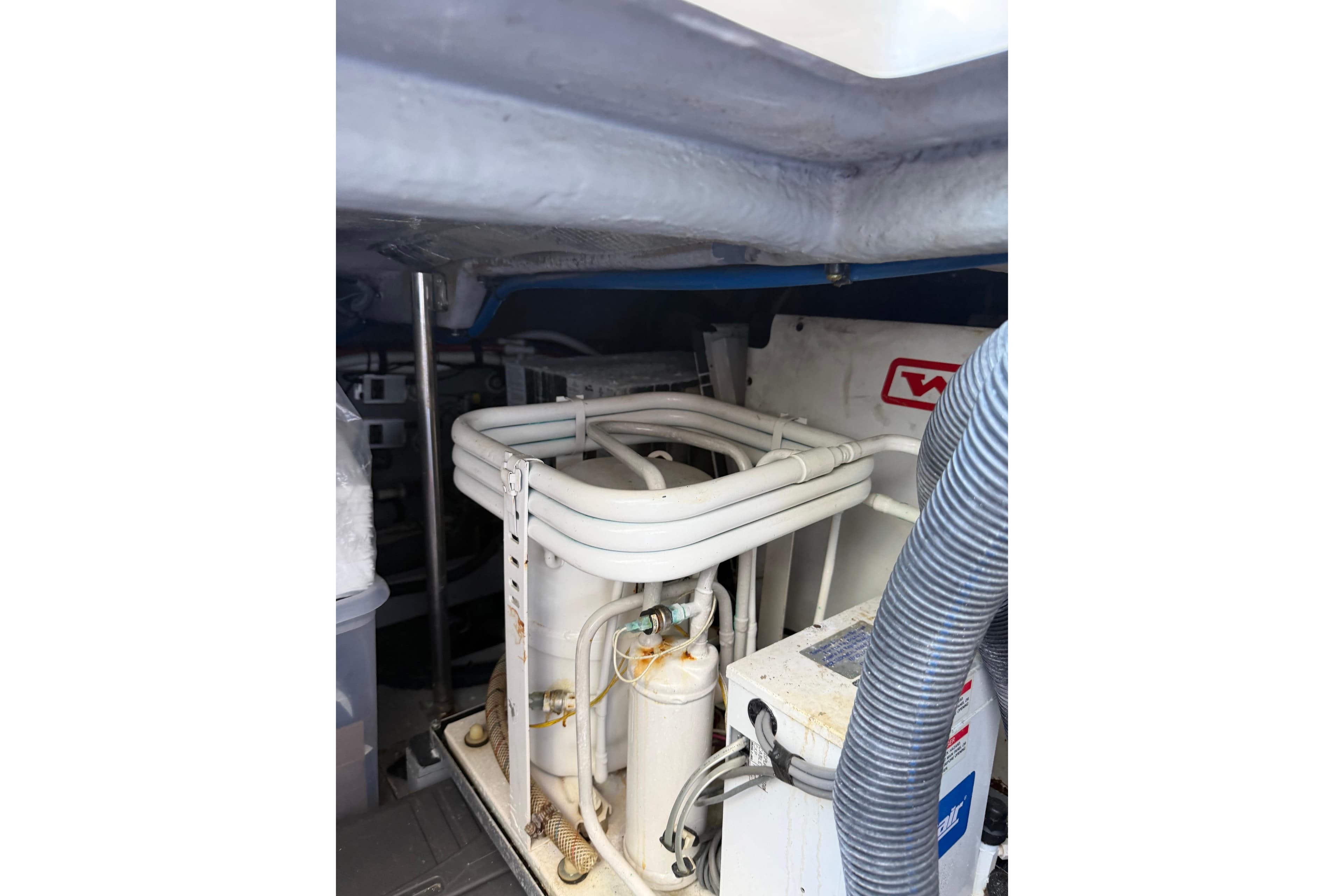 Engine room of 2002 Sea Ray 480 Sedan Bridge with visible machinery and piping.