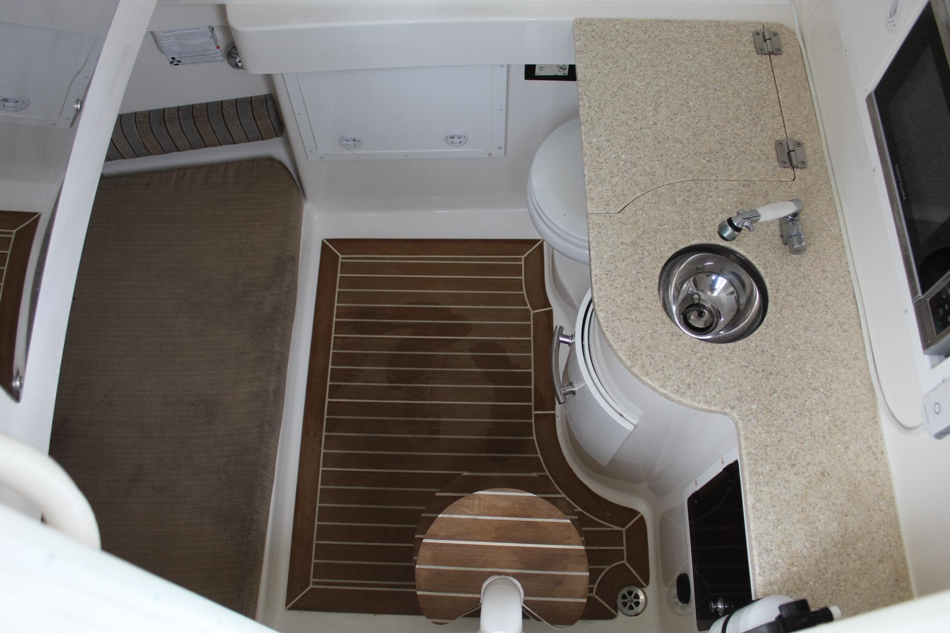 Interior of 2014 Regulator 34 SS boat with sink, toilet, and wooden flooring.