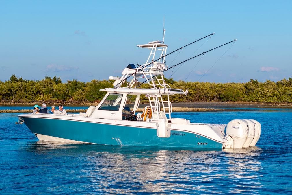 2026 Everglades 375 Center Console boat cruising on blue water with fishing rods.