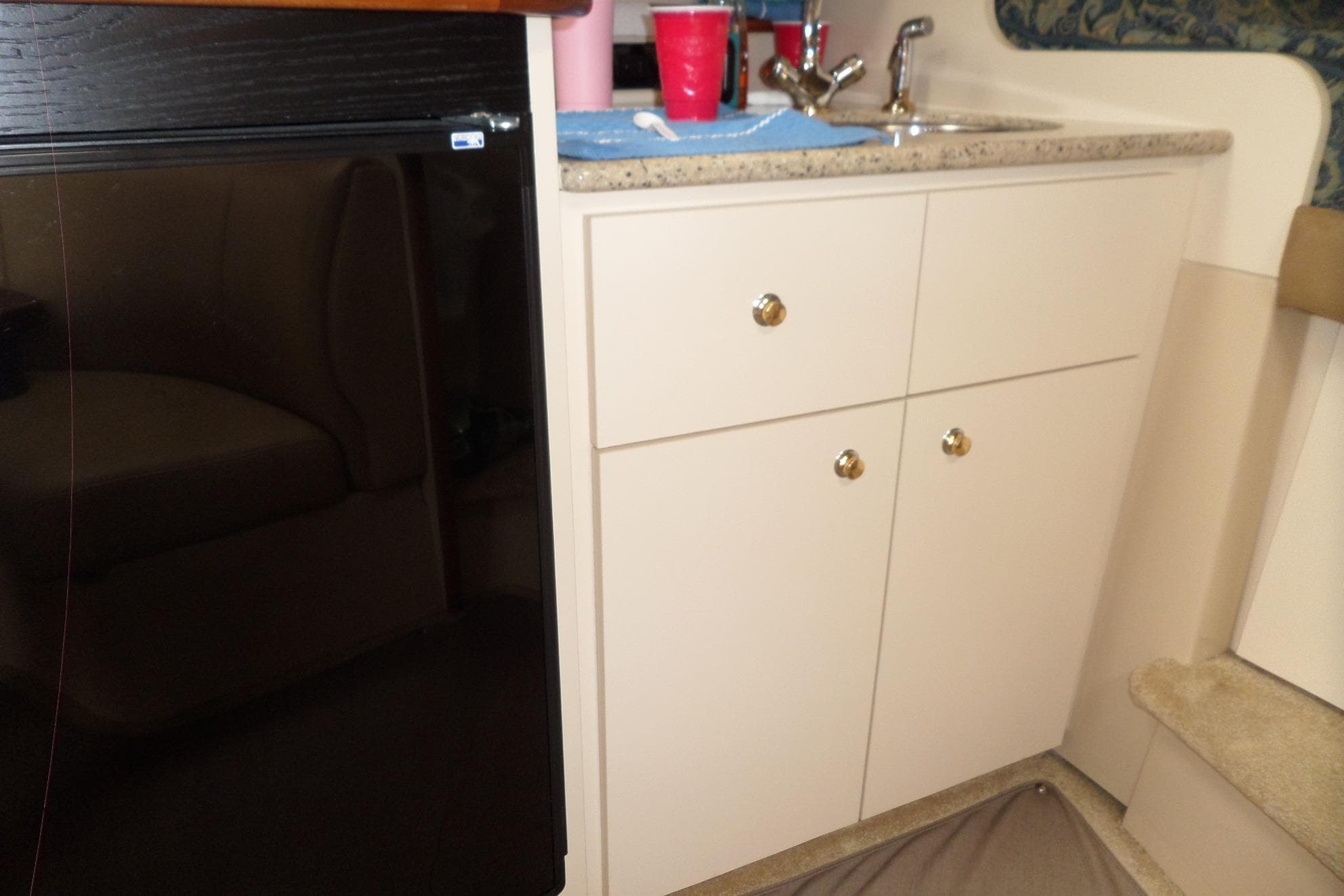2003 Cruisers Yachts 3275 Express interior with sink, cabinets, and mini fridge.
