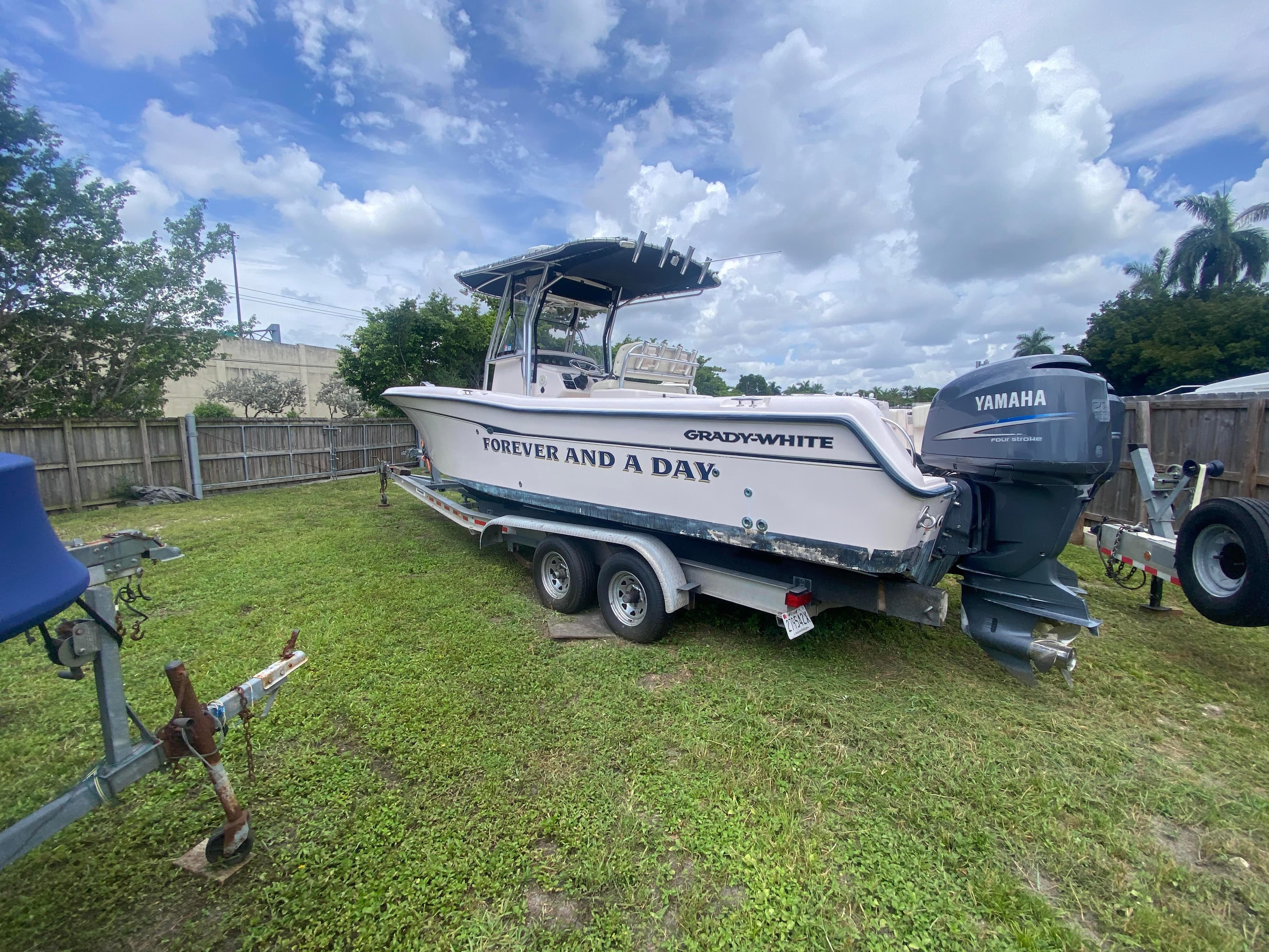 2003 Grady-White 283 RELEASE boat on trailer with Yamaha engine, parked on grass.