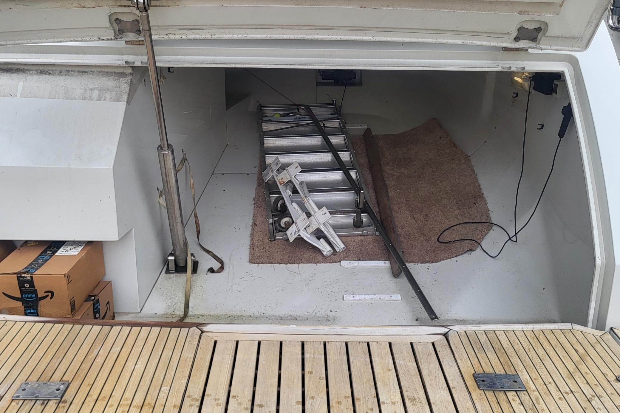 Storage compartment of a 2007 Azimut 68S yacht with equipment and Amazon boxes.