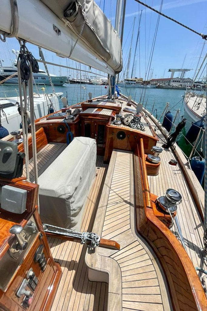 Luxurious 2004 Joubert-Nivelt TM 52 sailboat with wooden deck and marina backdrop.