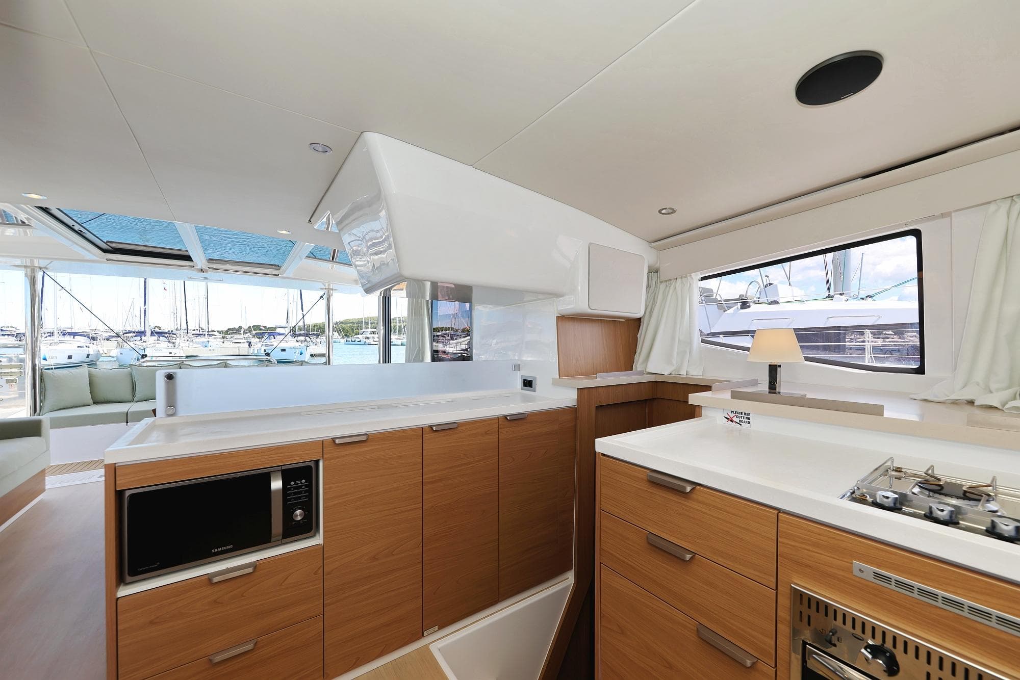 Modern kitchen interior on 2025 Bali 4.4 yacht with wood cabinets and marina view.