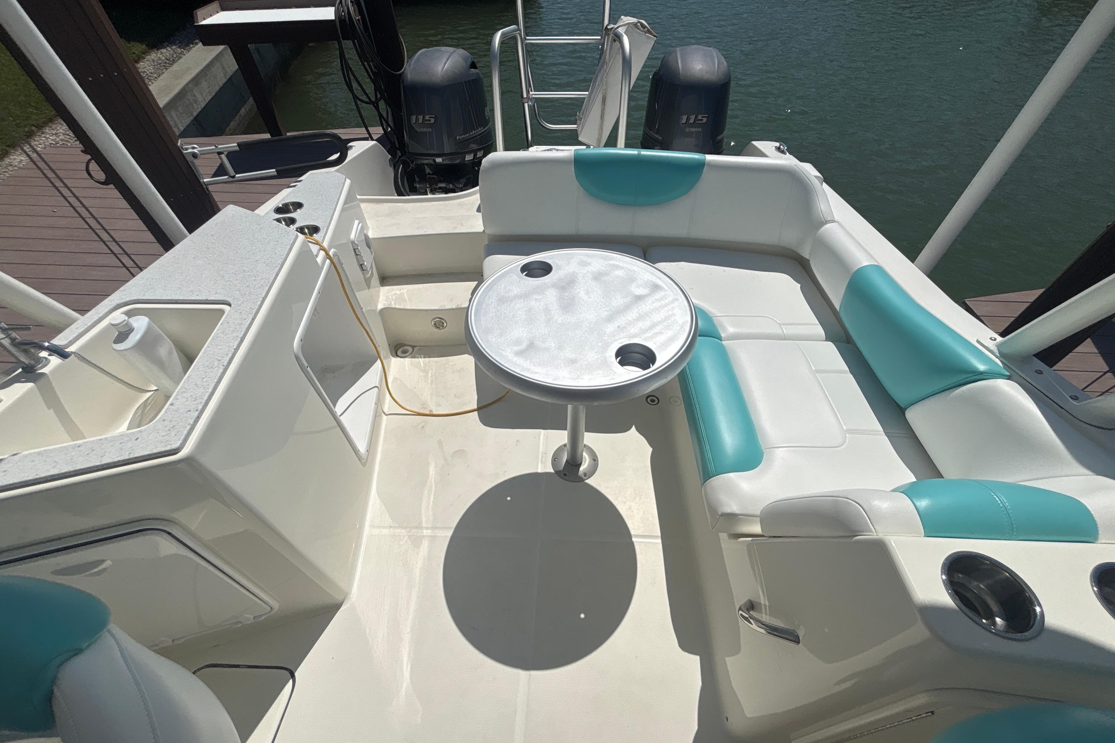 2018 World Cat 230 SD boat interior with seating, table, and dual outboard motors.