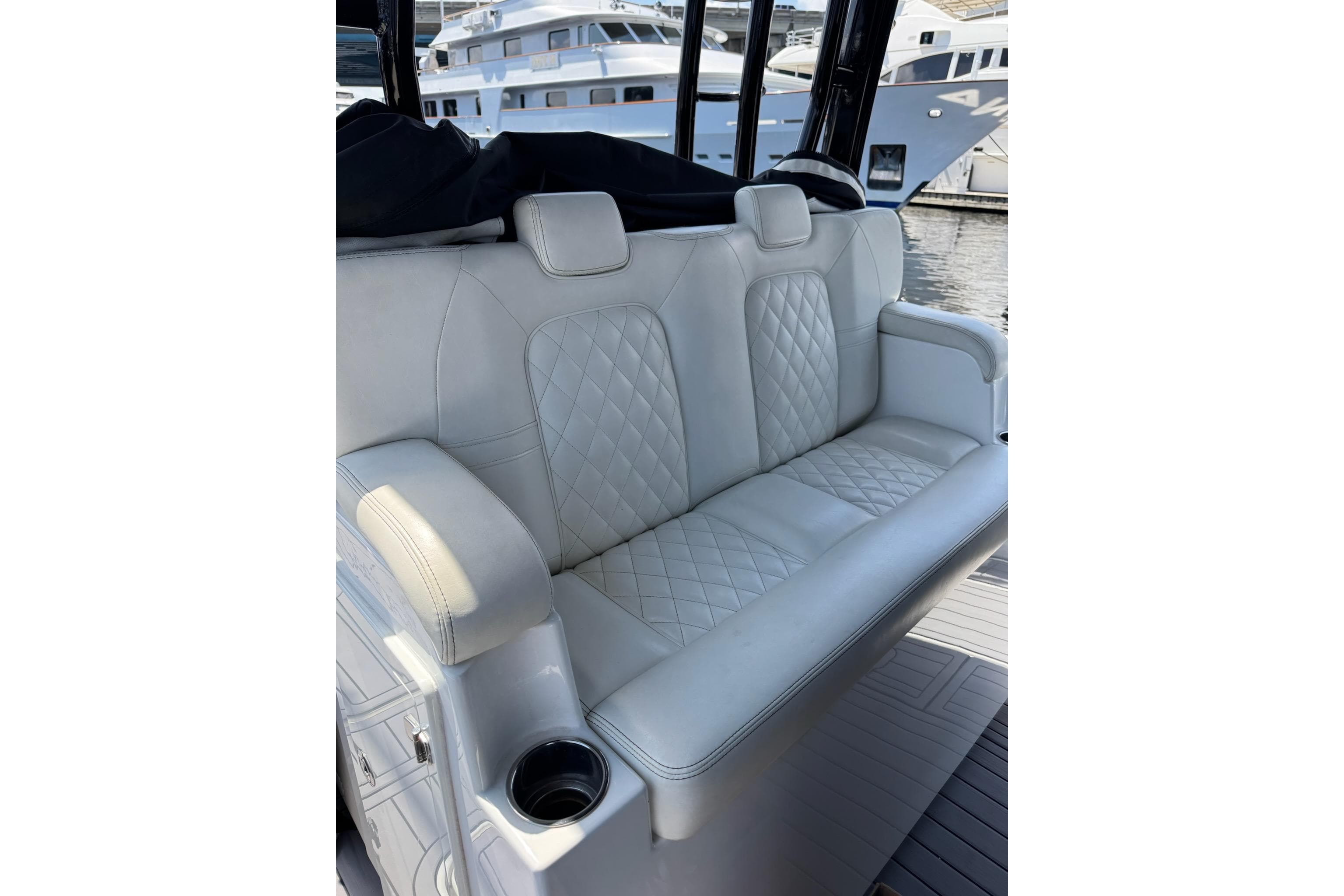 Luxurious white seating on 2019 HCB 42 Siesta boat, featuring diamond stitching and armrests.