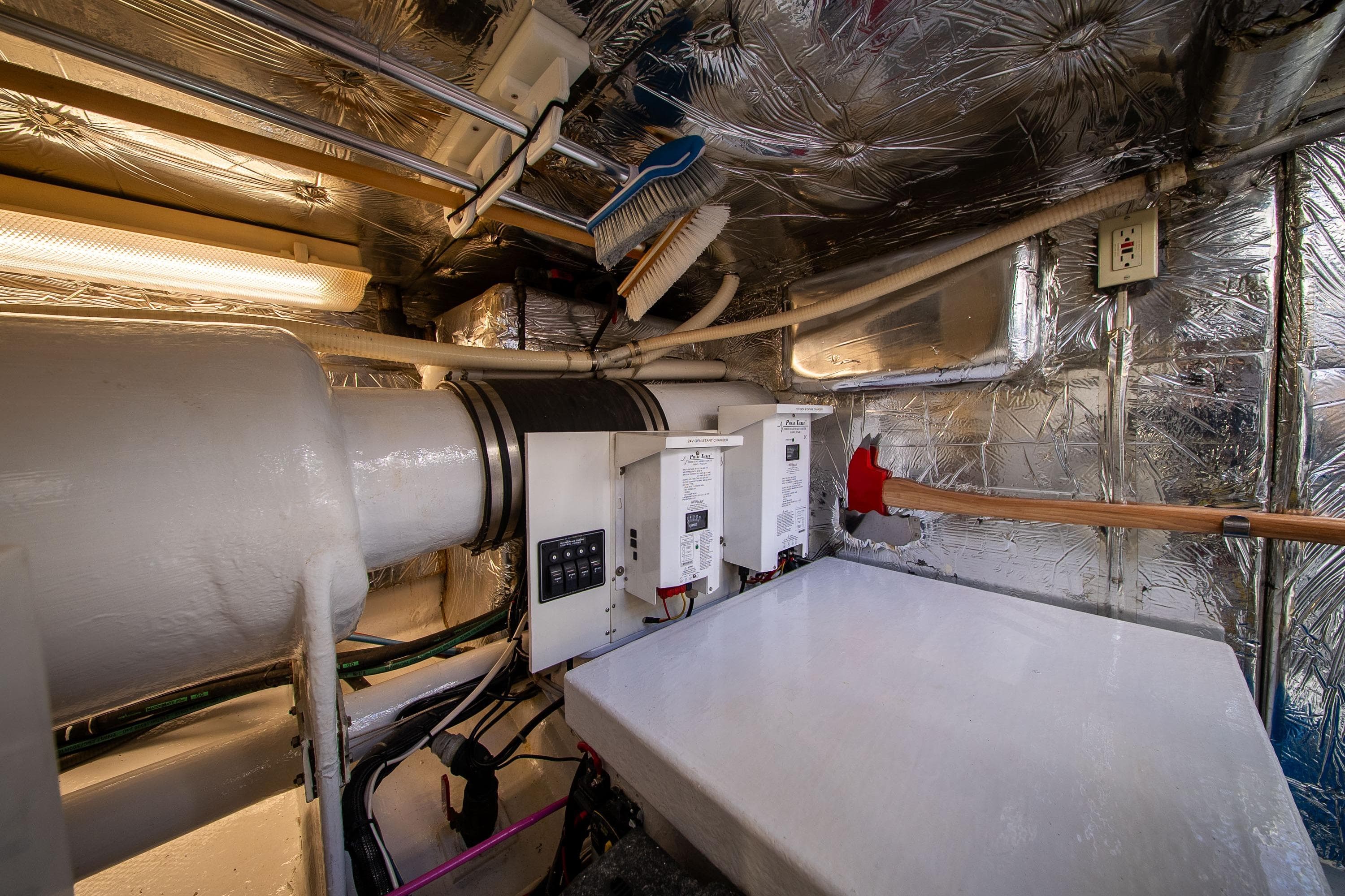 Engine room of 1988 Philbrooks Bill Garden Pilot House Motor Yacht, featuring insulated walls and equipment.