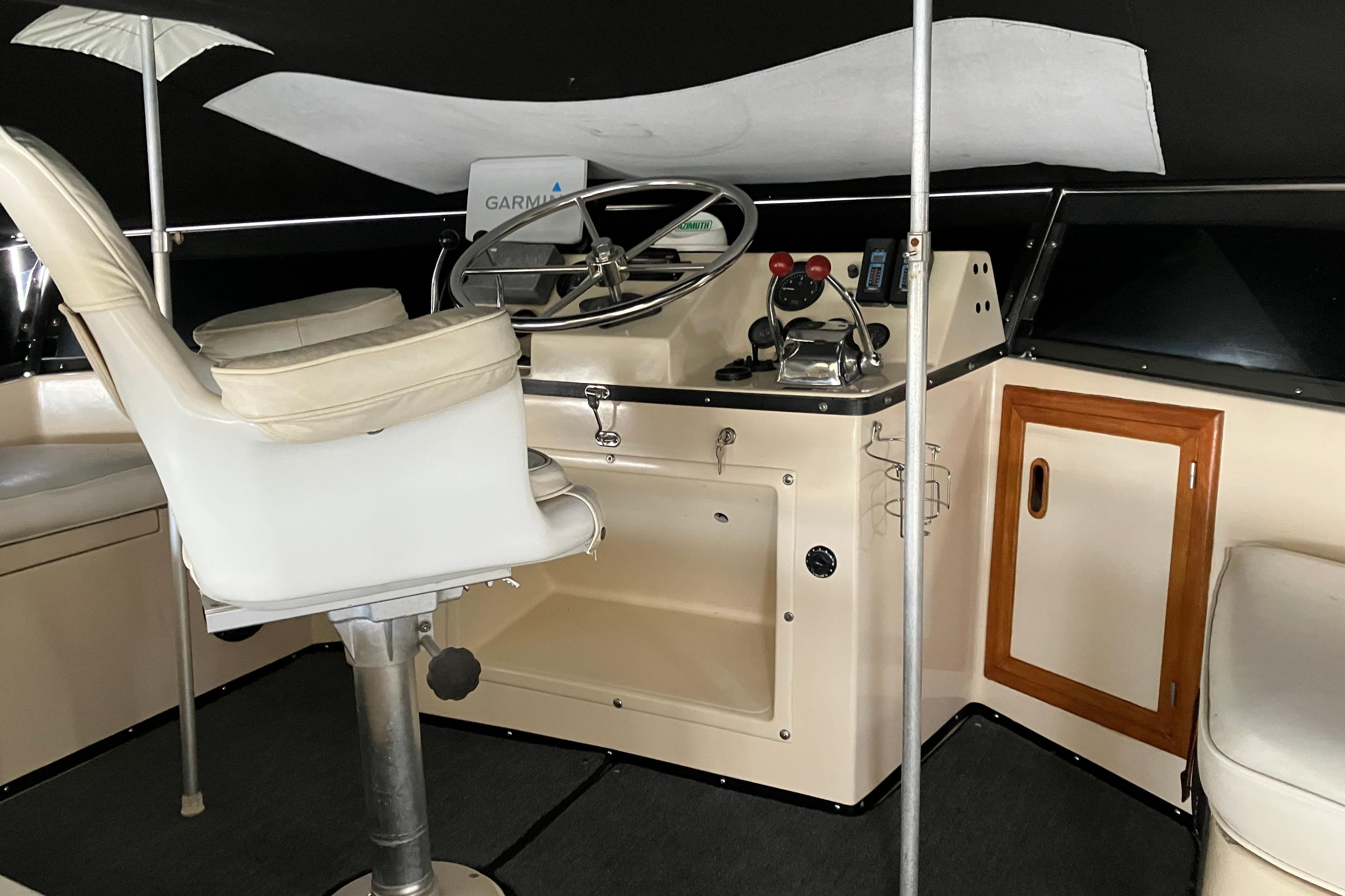 1987 President 37 Sundeck yacht helm with steering wheel and captain's chair.