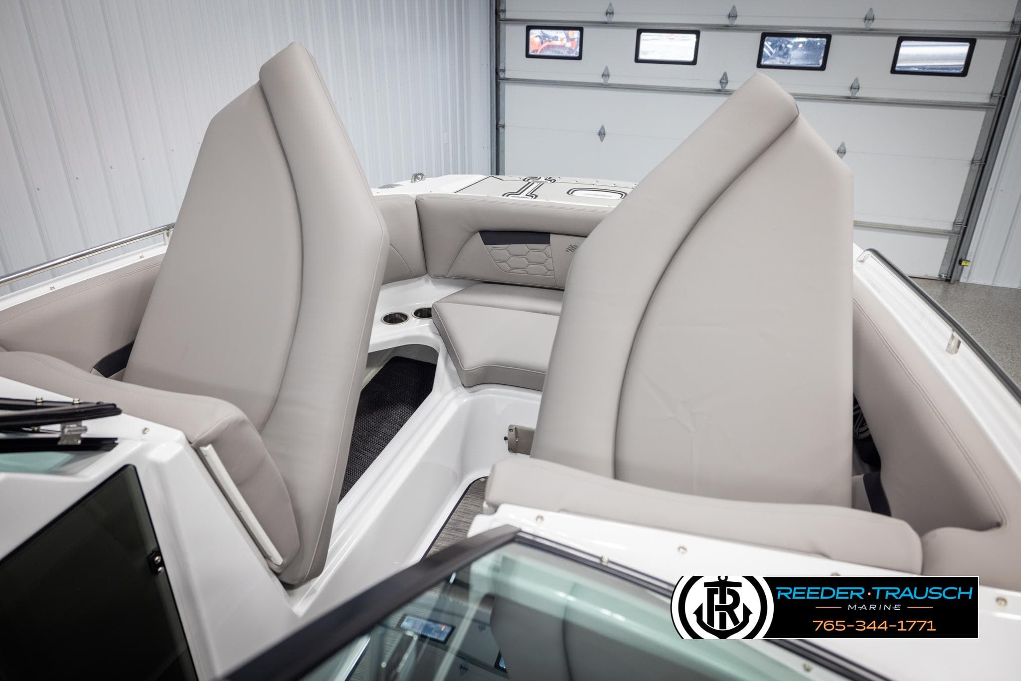 2025 Four Winns HD5 boat interior with beige seating in a showroom.