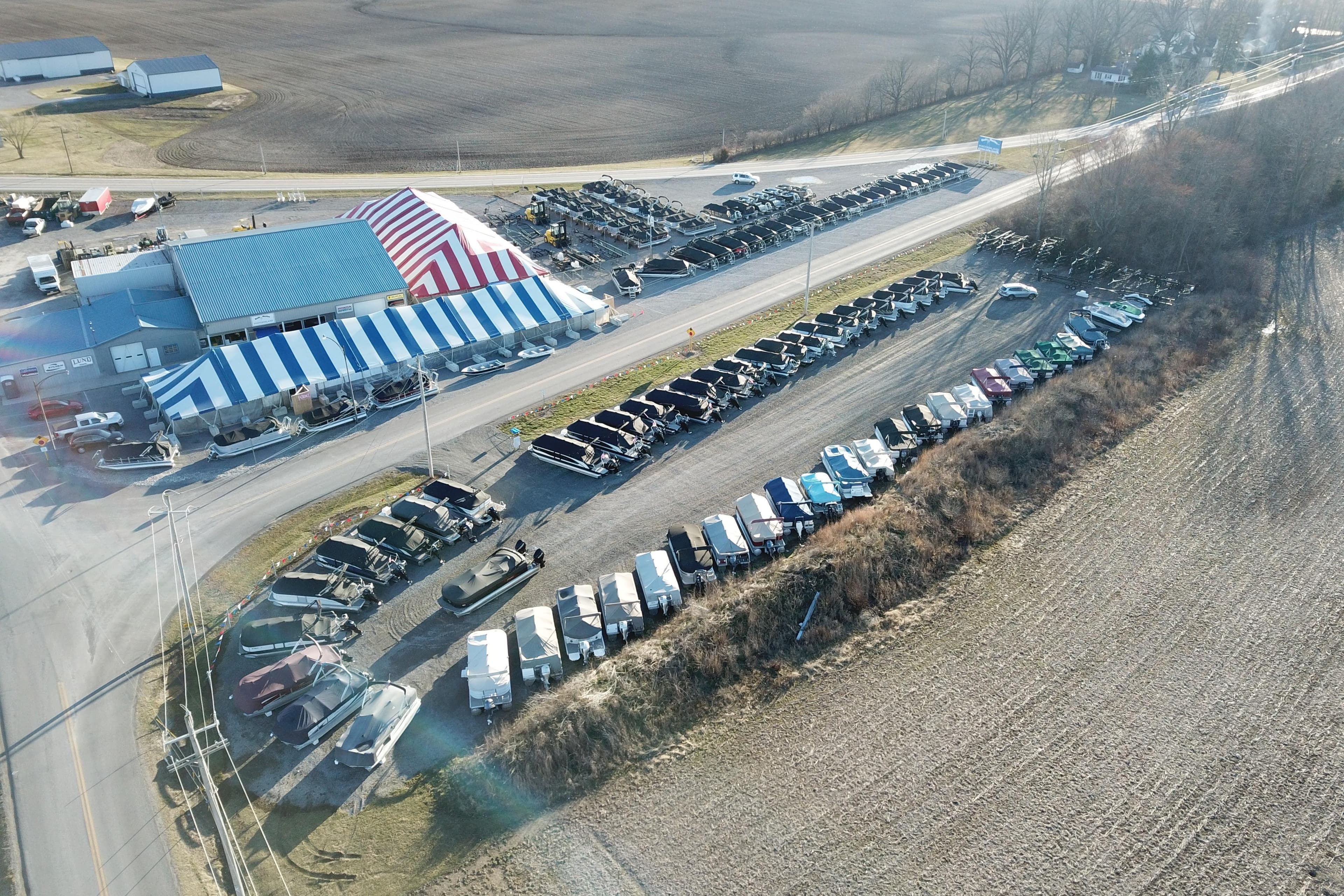 Aerial view of boat dealership with tents and vehicles, Starcraft EX 20 Q DH 2026.