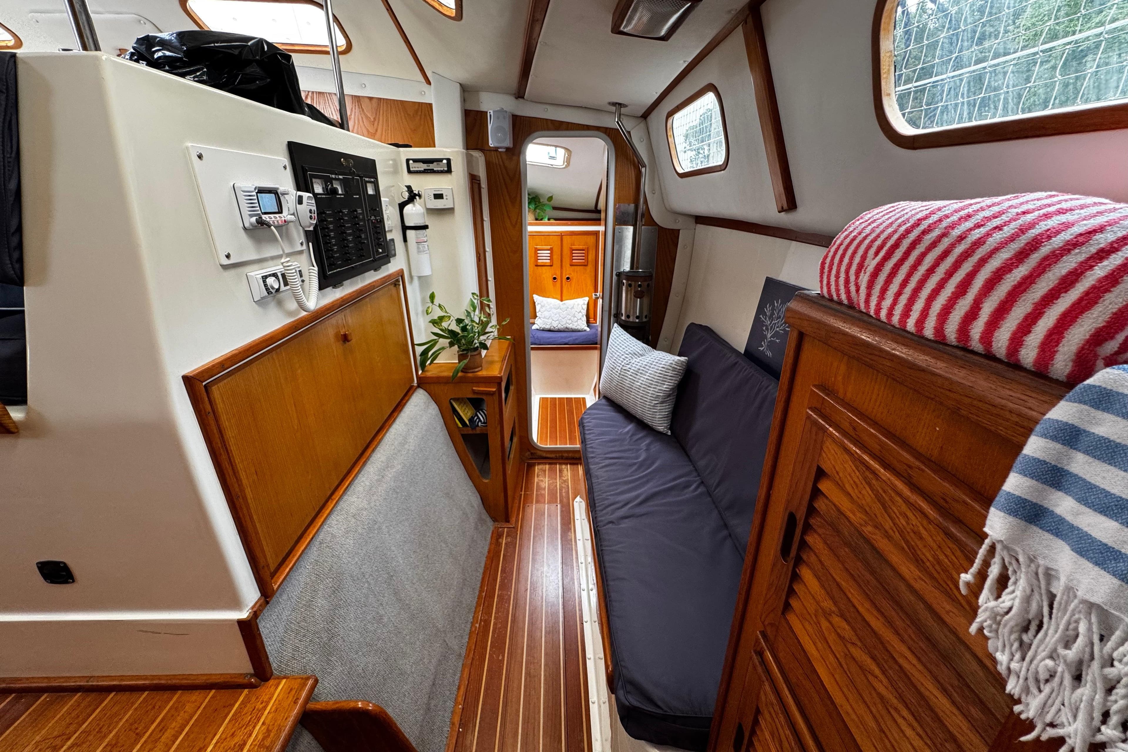 Interior of a 1991 PDQ 36 sailboat with cozy seating and wooden accents.
