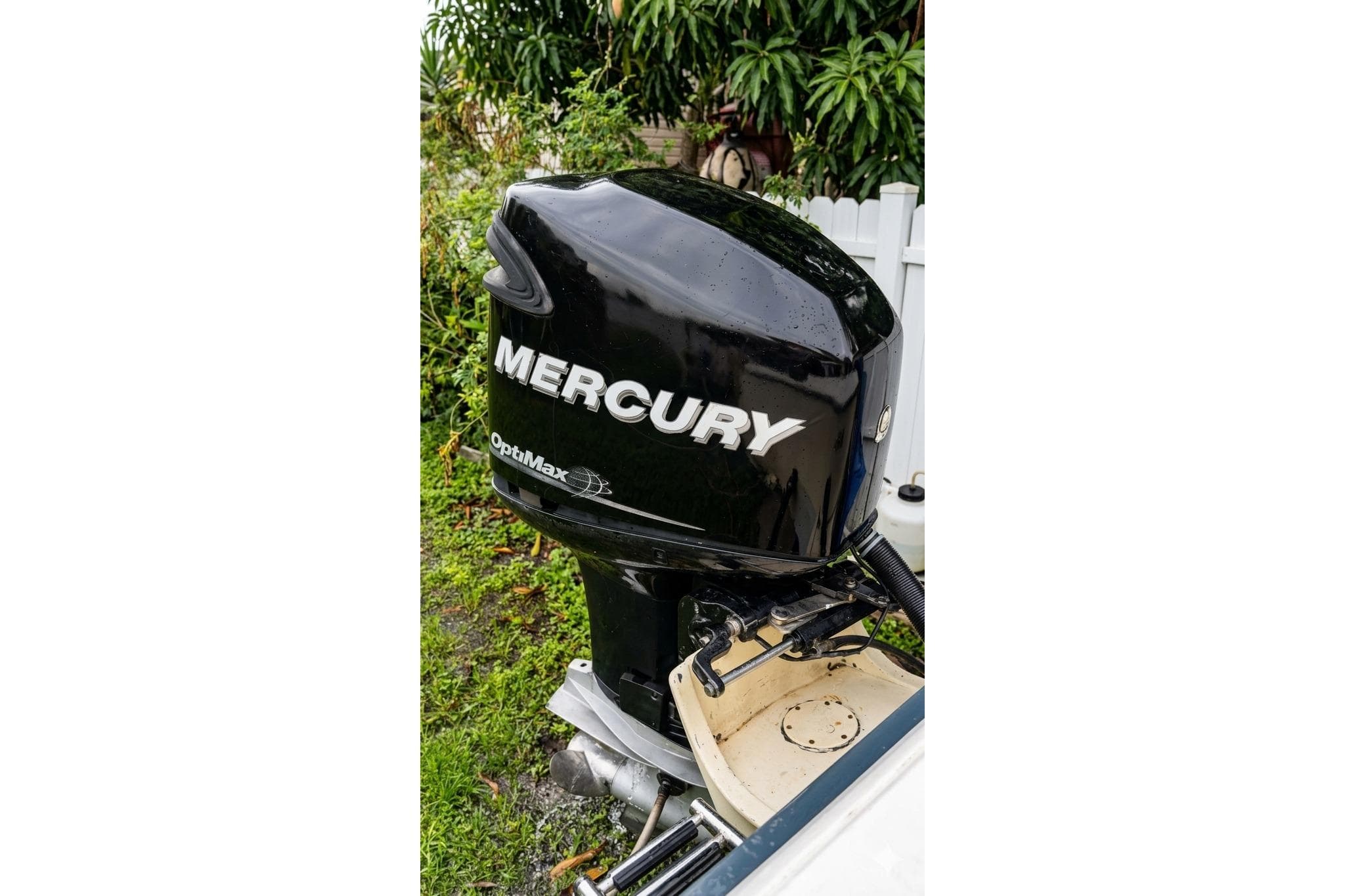 1989 Grady-White Offshore 242 with Mercury OptiMax outboard motor in a garden setting.