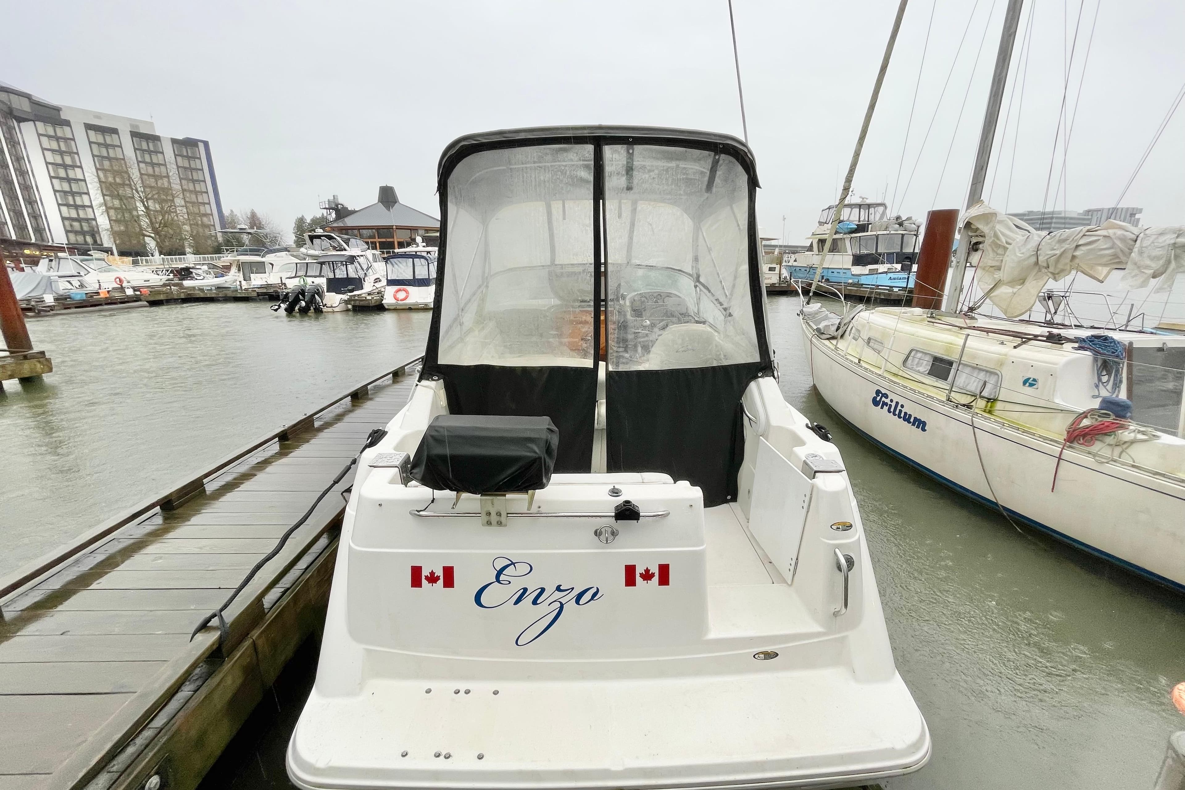 1997 Bayliner 2355 Ciera boat docked at marina with Canadian flags.