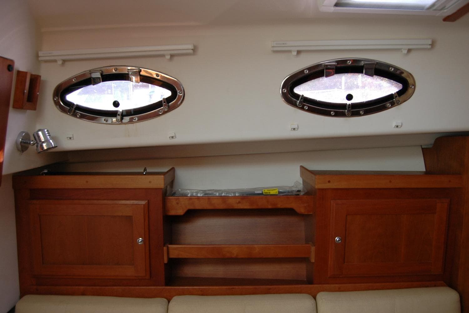 Interior of 2014 Back Cove 34 boat with wooden cabinets and oval windows.