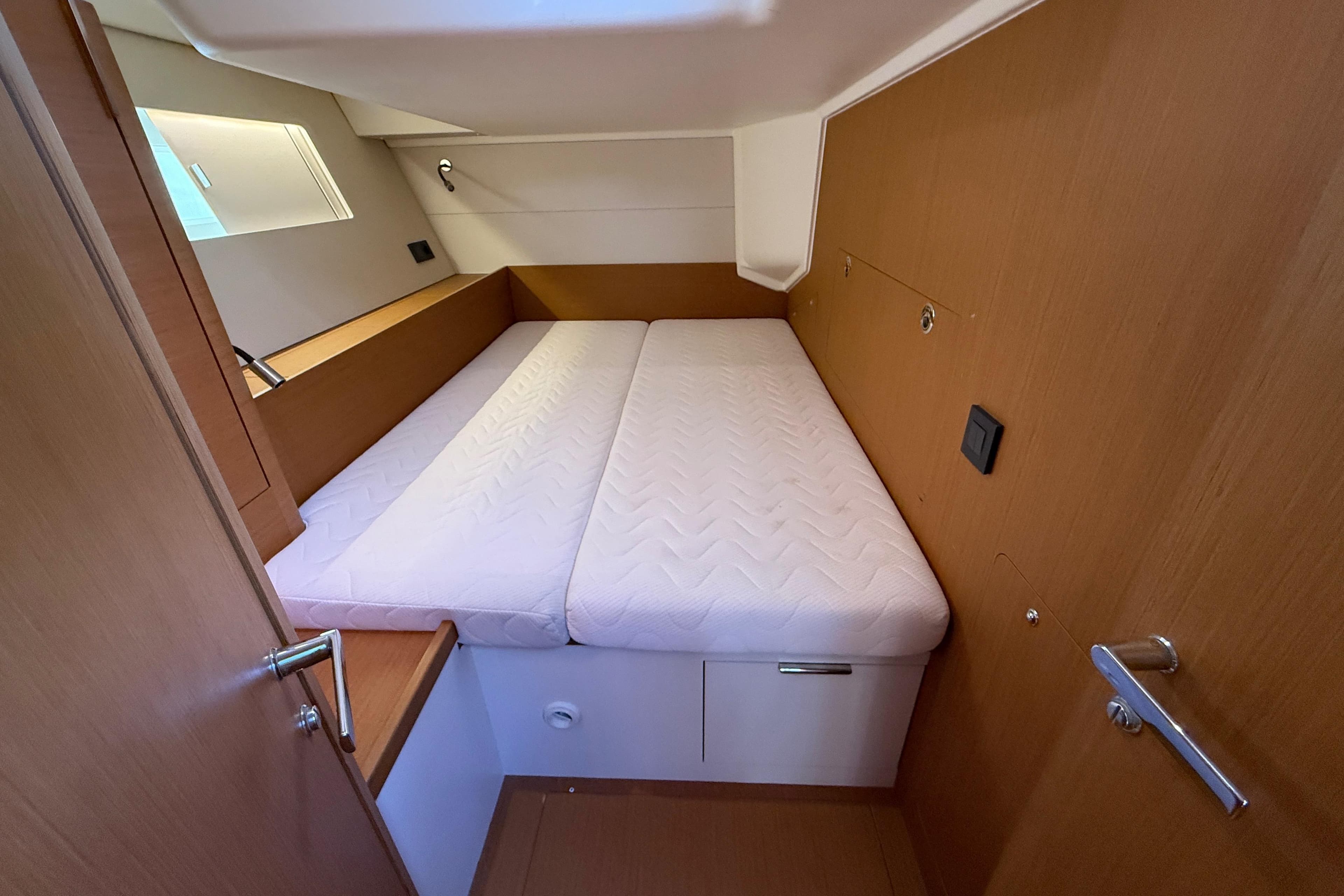 Cozy cabin interior of 2020 Beneteau First 53 yacht with comfortable bedding.