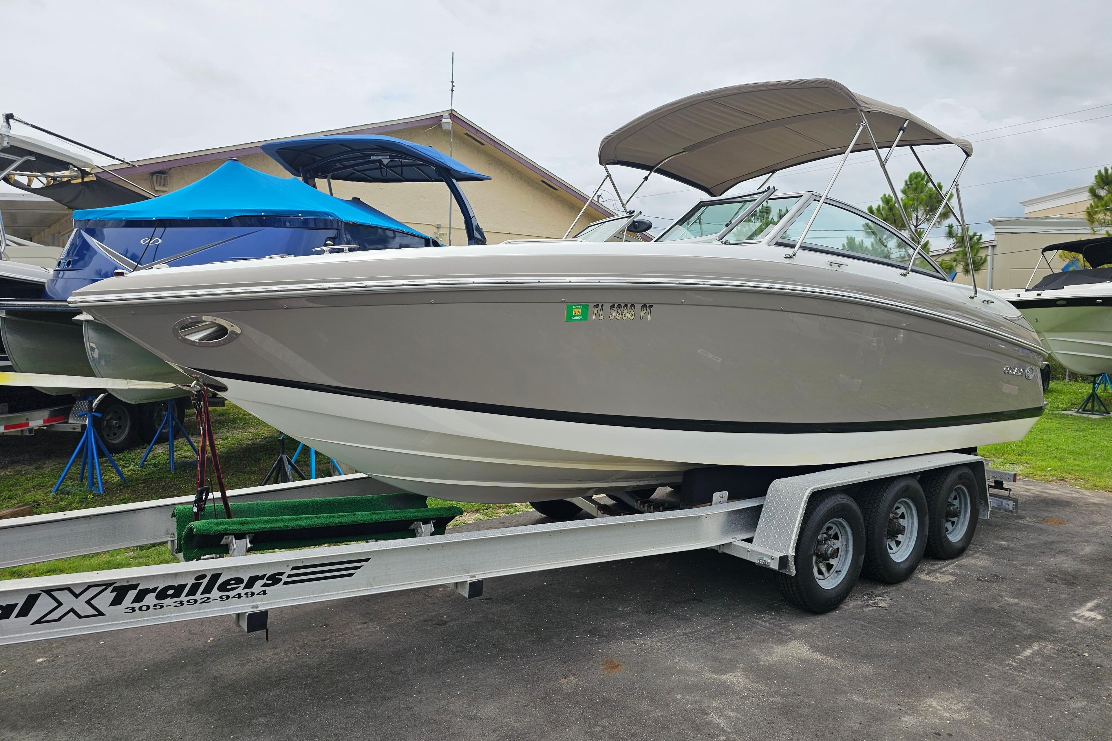 2012 Cobalt 242 boat on a trailer, parked outdoors with other boats nearby.