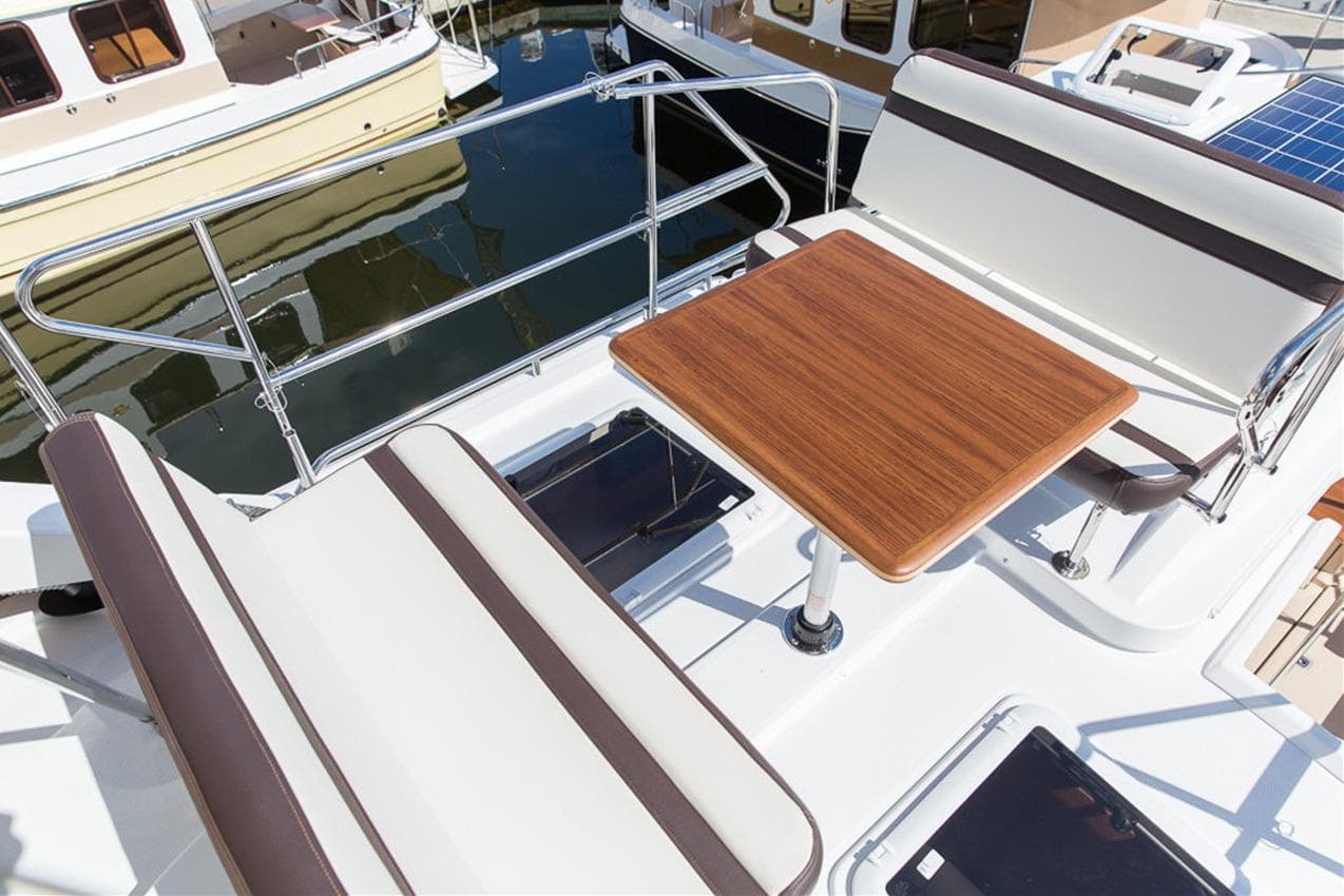 Manufacturer Provided Image: 2025 Ranger Tugs R-31 CB boat deck with seating and wooden table.