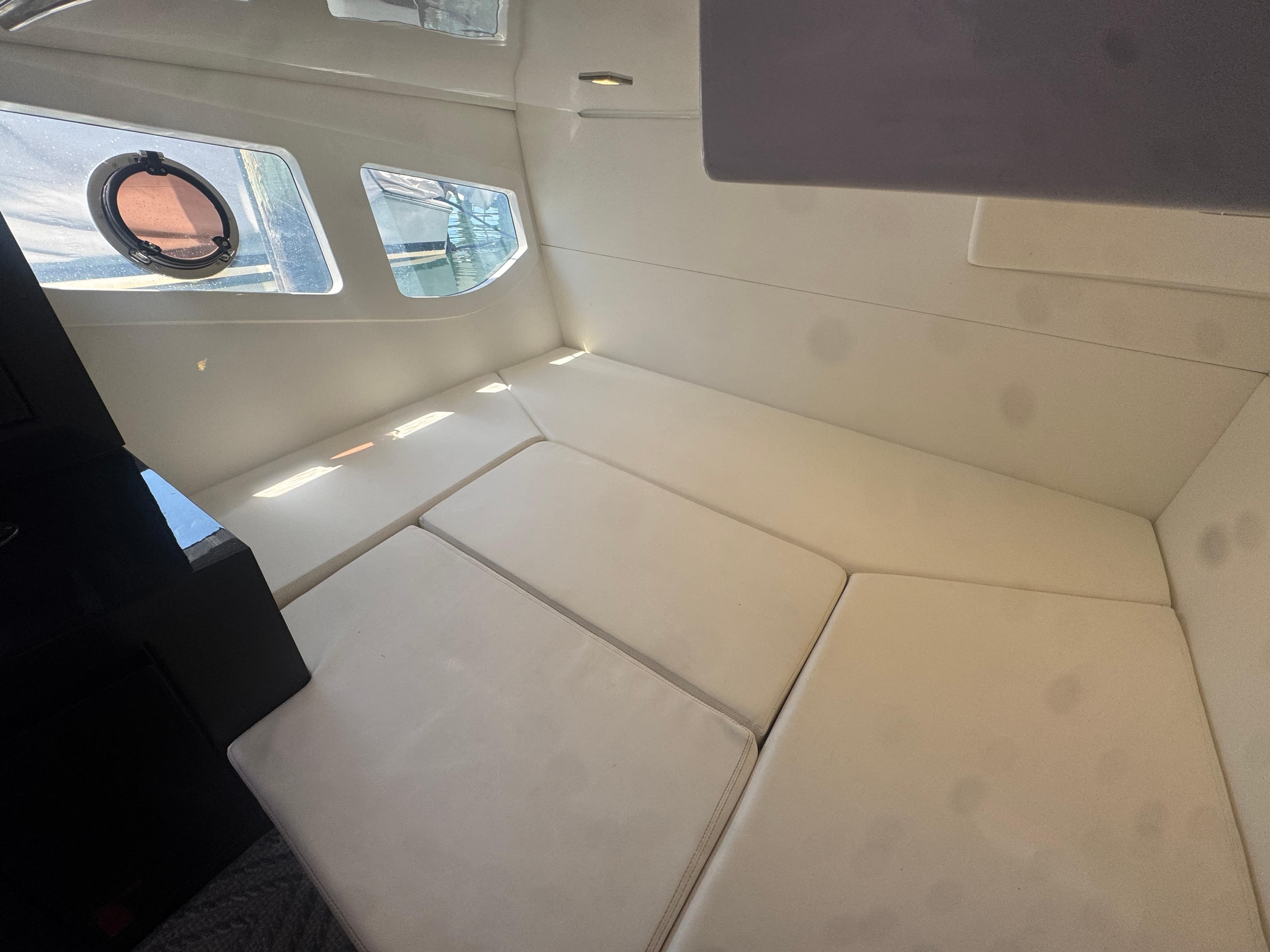 Interior cabin of 2023 Schaefer 375 HT yacht with beige seating and windows.