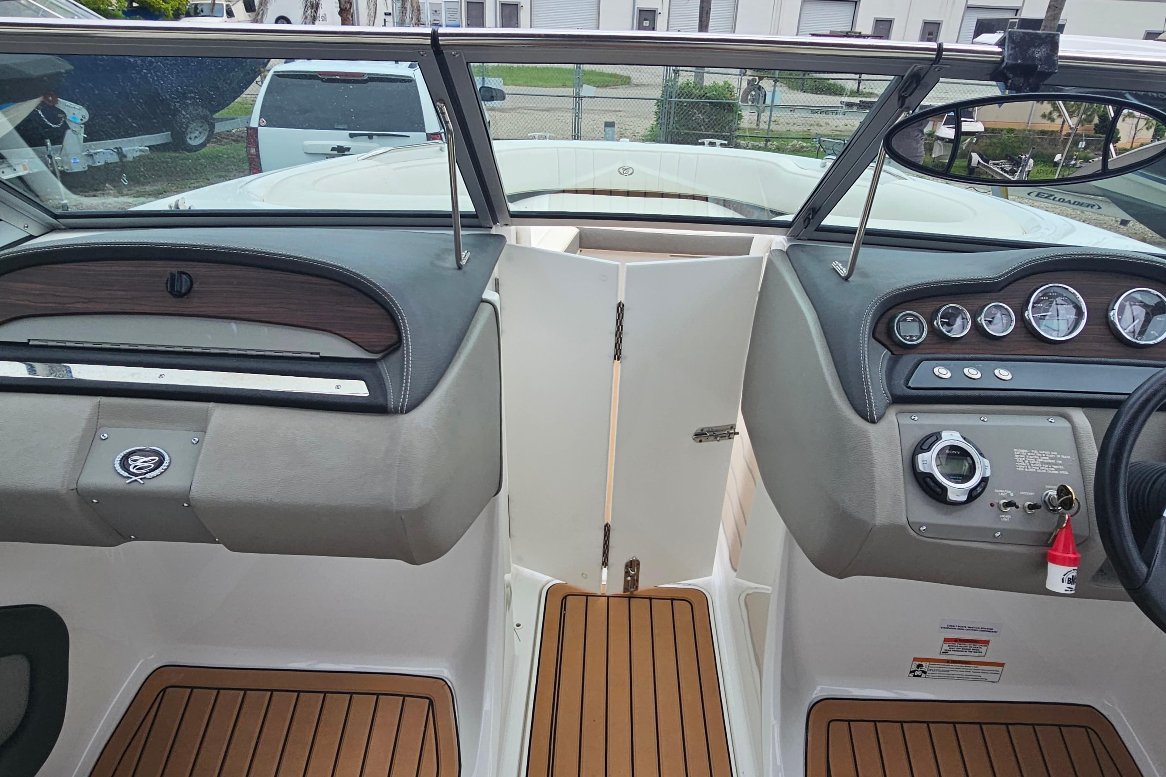 Interior view of a 2012 Cobalt 242 boat dashboard with wood accents and gauges.