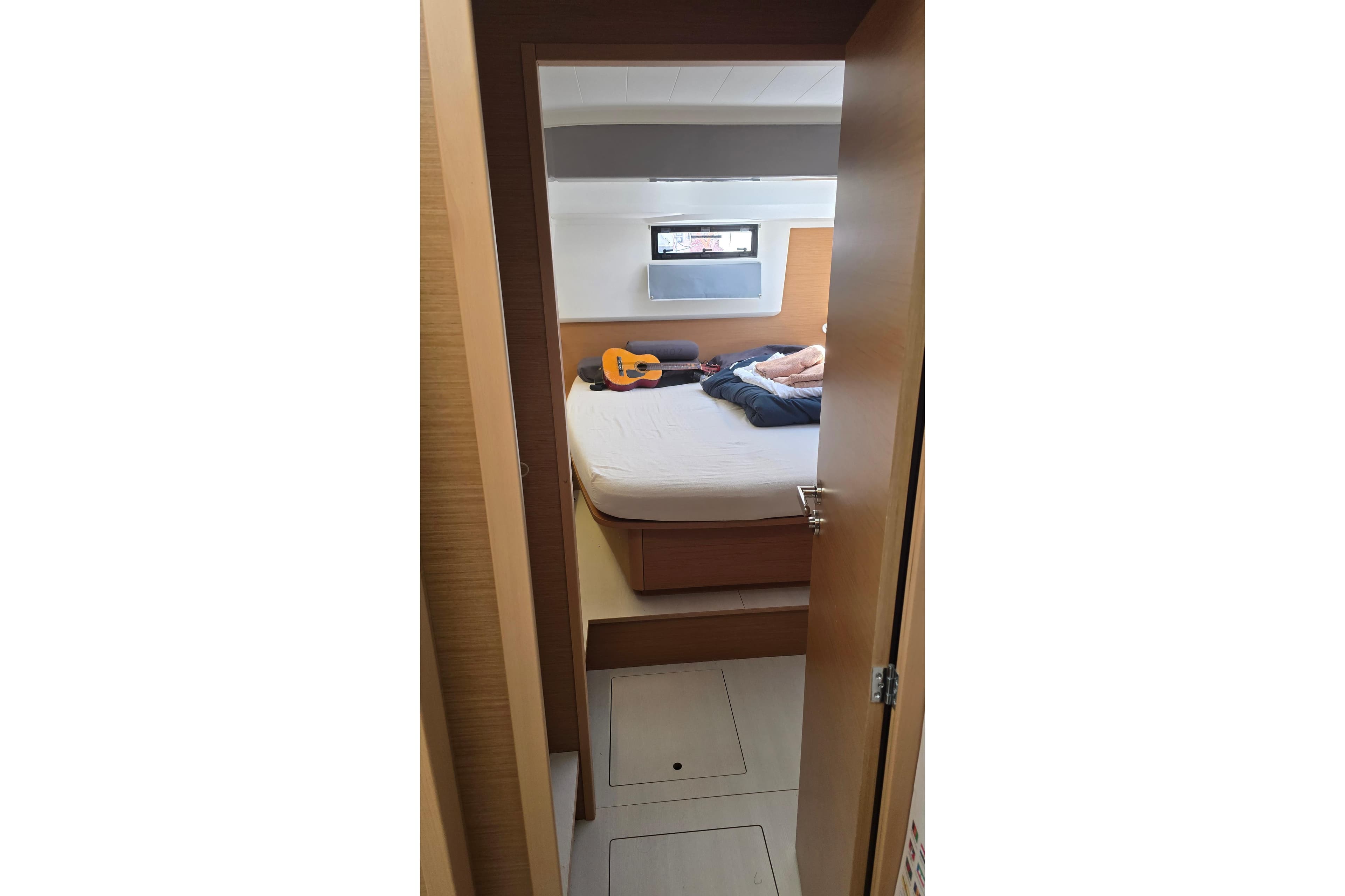 Interior cabin view of 2024 Excess 14 yacht with bed and guitar.