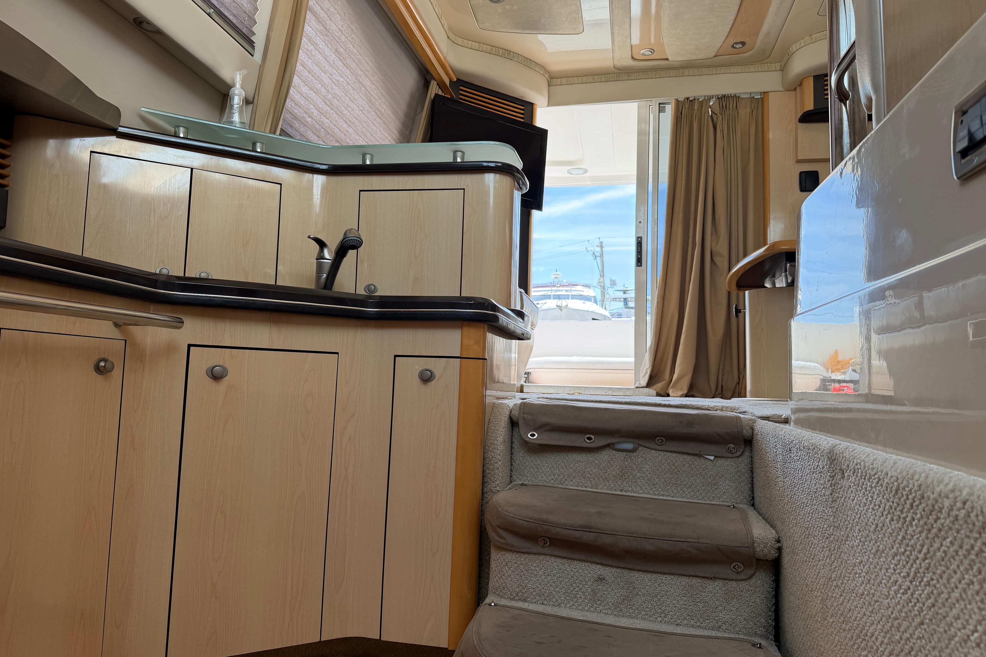 Interior view of 2004 Sea Ray 420 Sedan Bridge yacht, featuring kitchen and stairs.