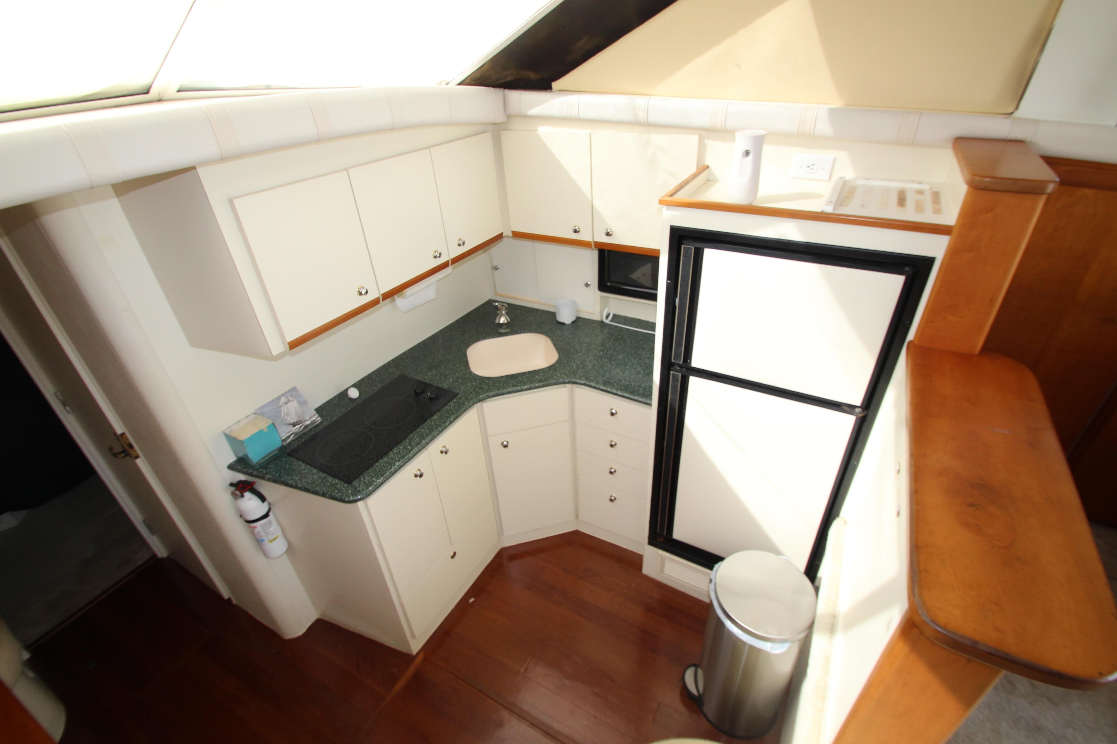2000 Silverton 37 Convertible yacht kitchen with white cabinets and green countertops.