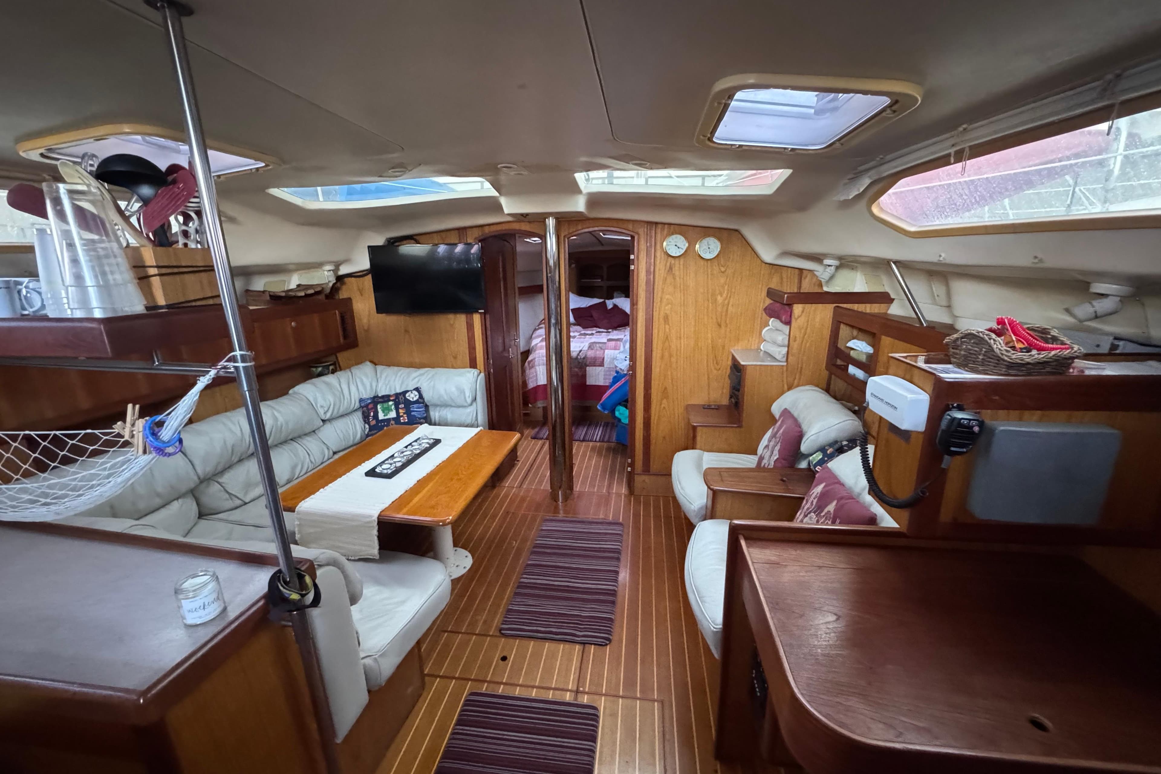 Interior of a 2000 Hunter 460 sailboat with cozy seating and wooden finishes.